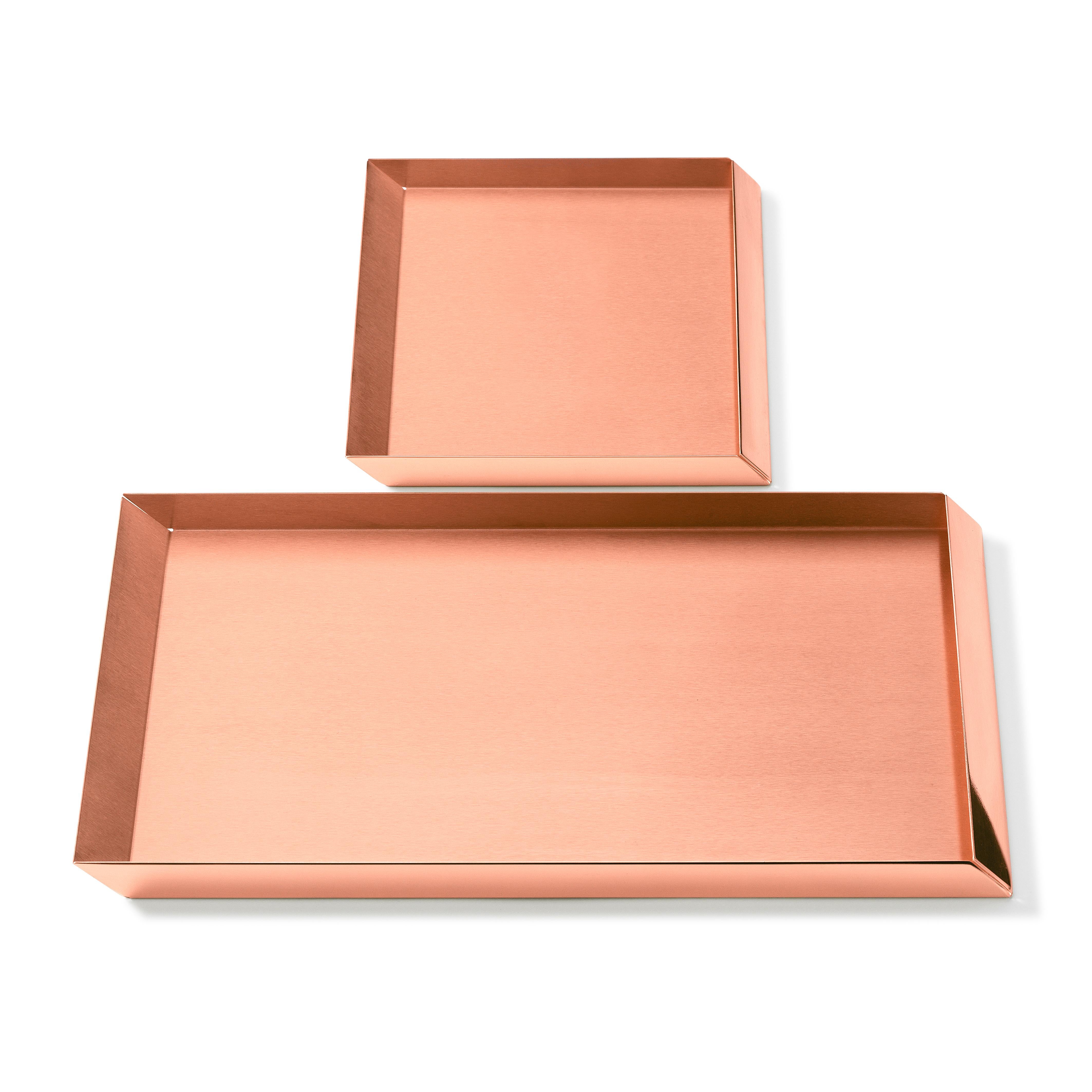 The compositional scheme of this family of small trays is the axonometric isometric projection of two parallelepipeds which creates a three-dimensional optical effect implemented by inclined edges and by contrasting metal finishes. Like in a game,