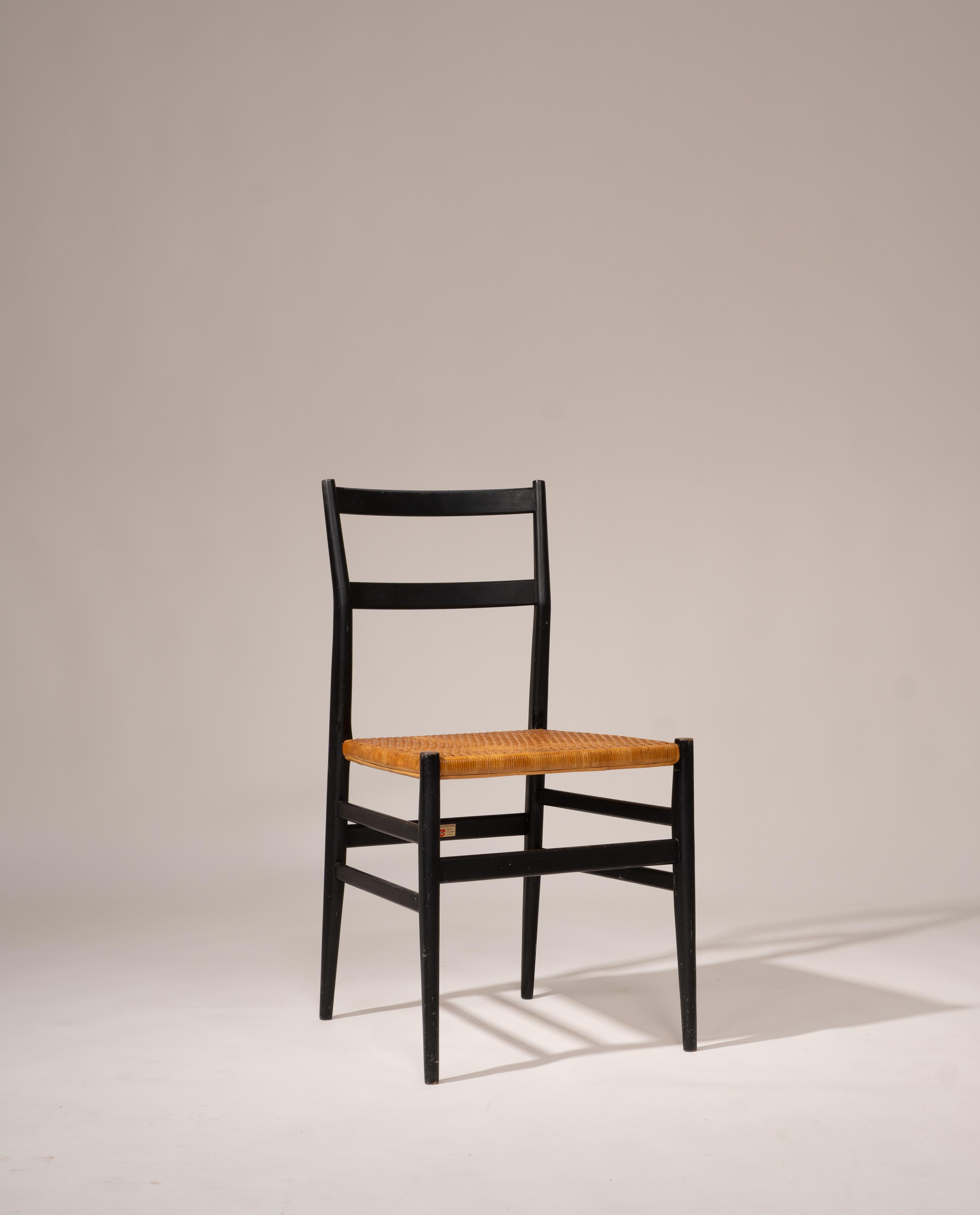 Set of two Superleggera chairs designed by Gio Ponti for Cassina, Italy, 1957. Constructed from solid ash wood and painted black, each chair features a woven straw seat for comfort and durability. The design is characterized by a lightweight,