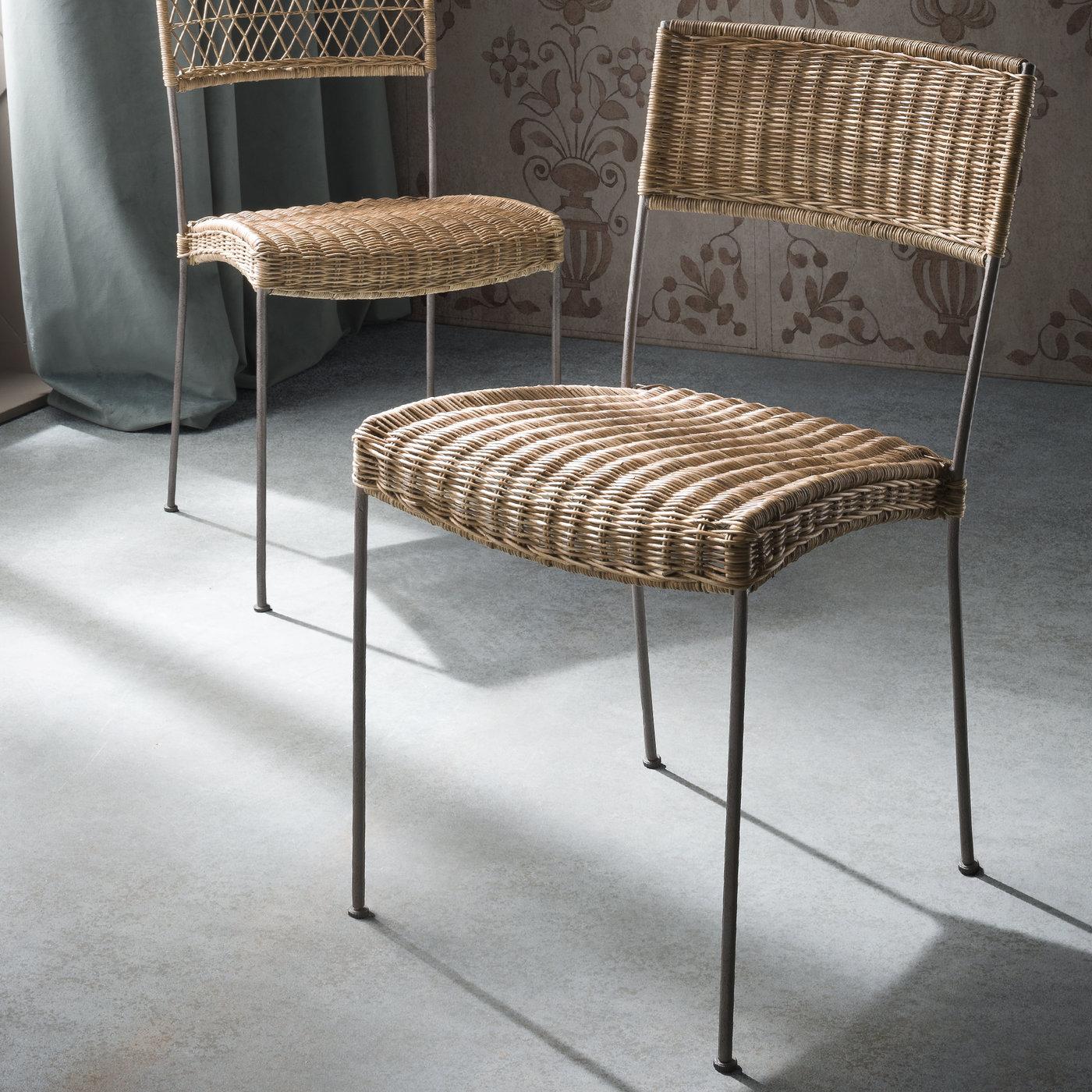 Evoking the image of a French terrace or a patio in Tuscany, this set of chairs has a classic design reinterpreted with a metal frame and woven bamboo details. Light and versatile, the slim, cylindrical legs support the generous seat, whose curves