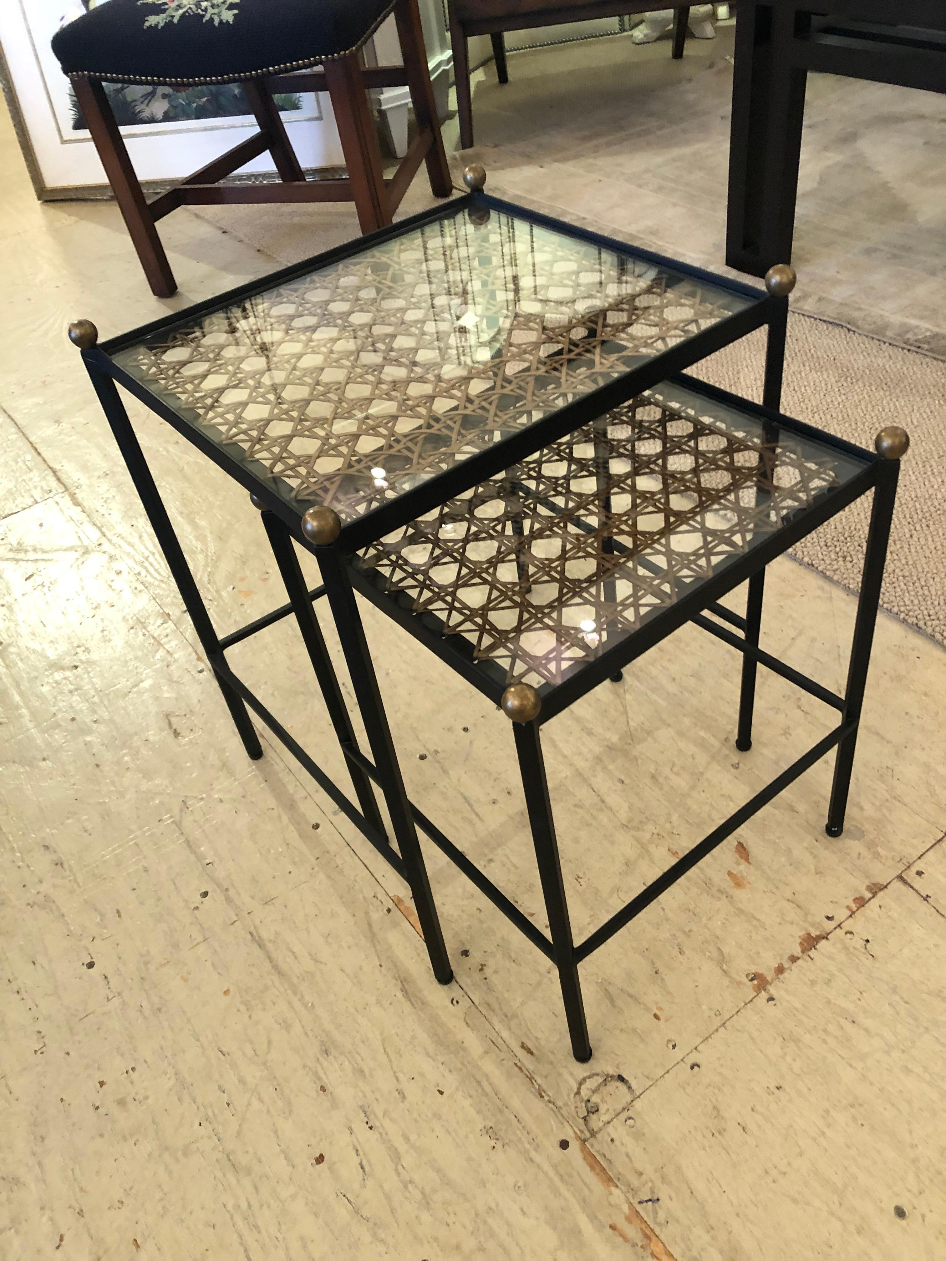 Two stylish and very functional black metal nesting tables having decorative cane underneath glass tops and handsome brass finials.
small table 12 W 12.5 D 17 H.