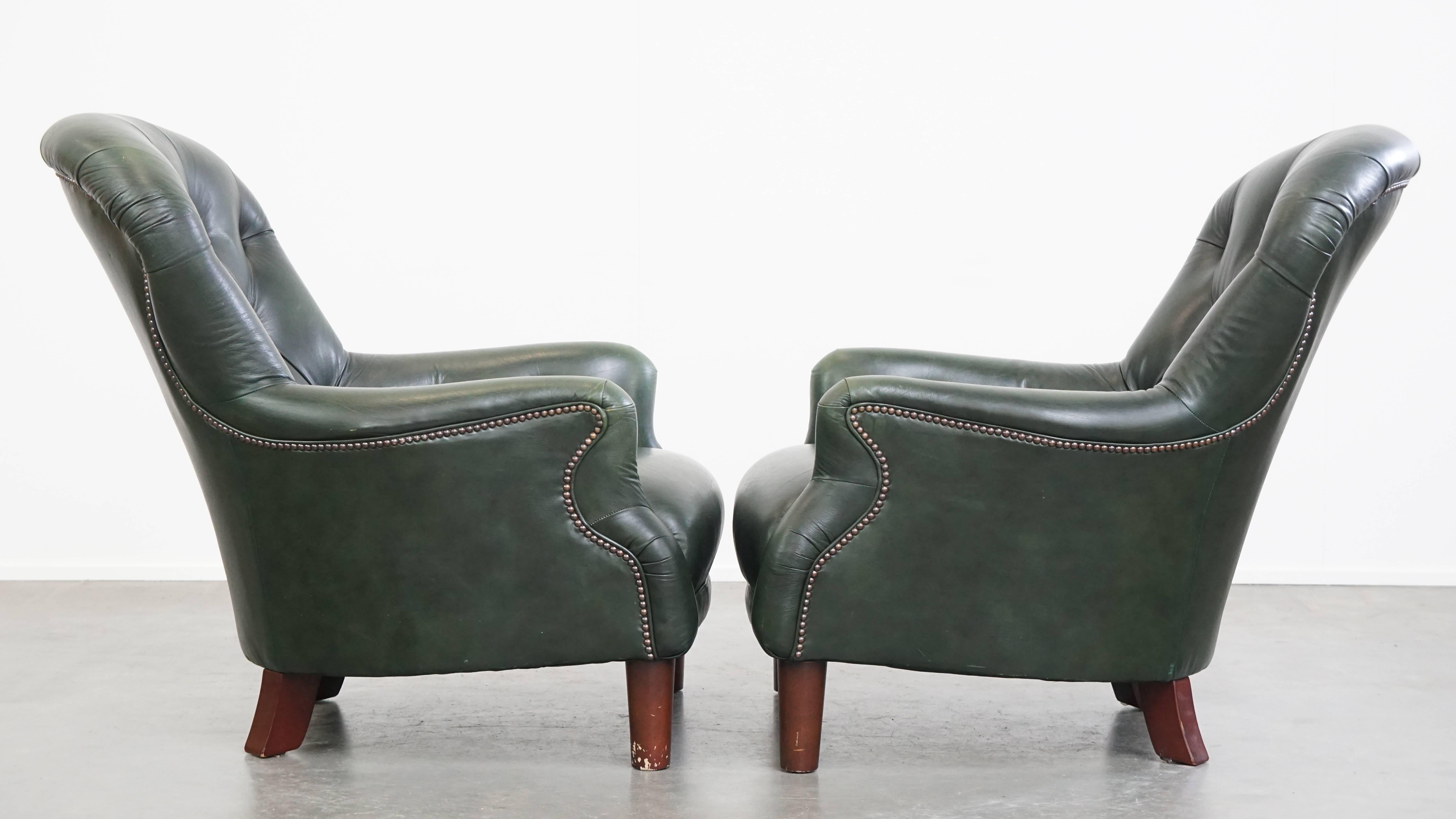Offered here is this very charming set of 2 green cowhide leather Chesterfield armchairs in classic English style.
These delightful green leather Chesterfield armchairs not only bring a stylish appearance to the room of your choice, but they also