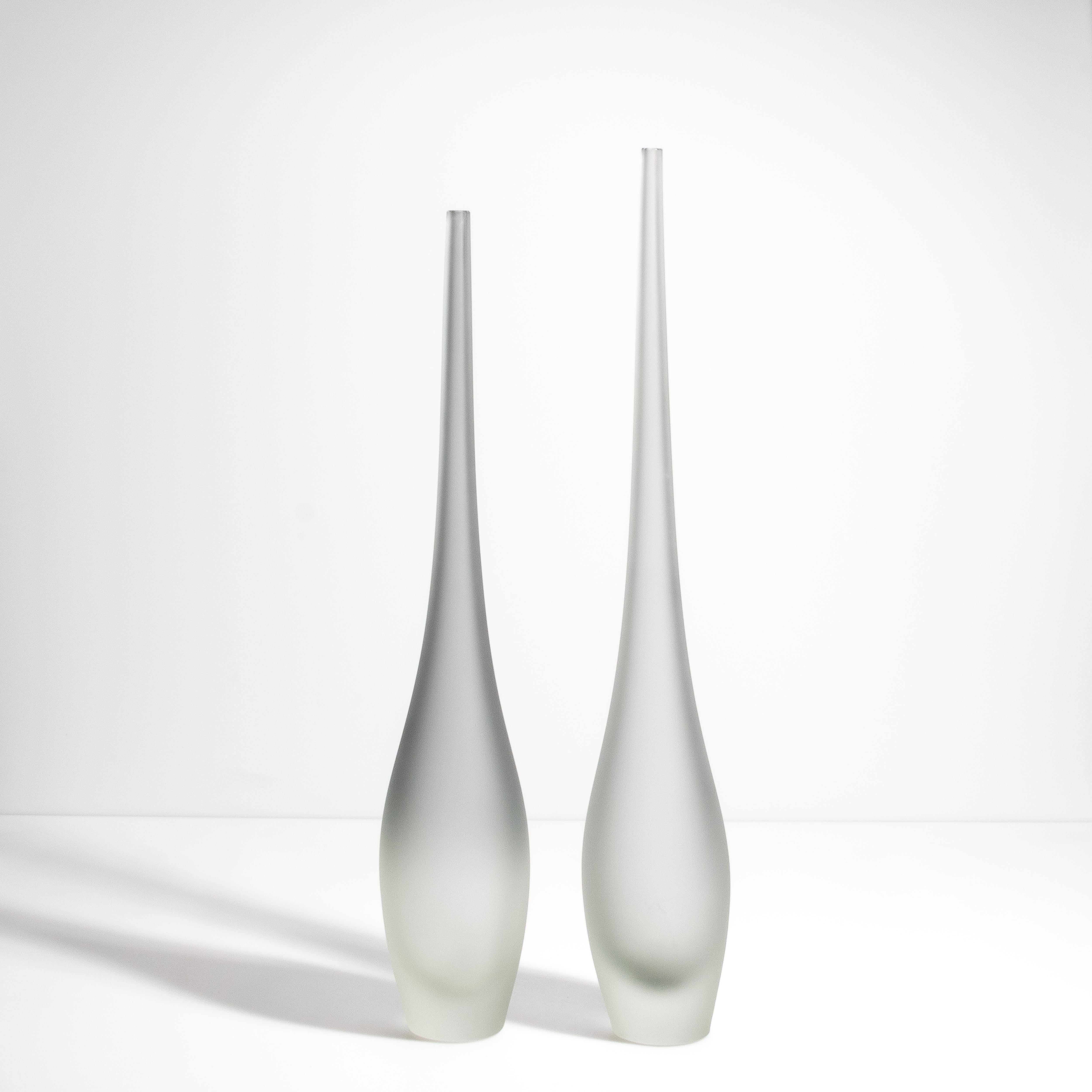 Introduci un tocco di serena eleganza nella tua casa con l'esclusivo set dei nostri bellissimi vasi a forma di flauto in un grigio sereno; un capolavoro ispirato alle delicate forme della natura. Questi vasi, con le loro forme allungate e fluide,