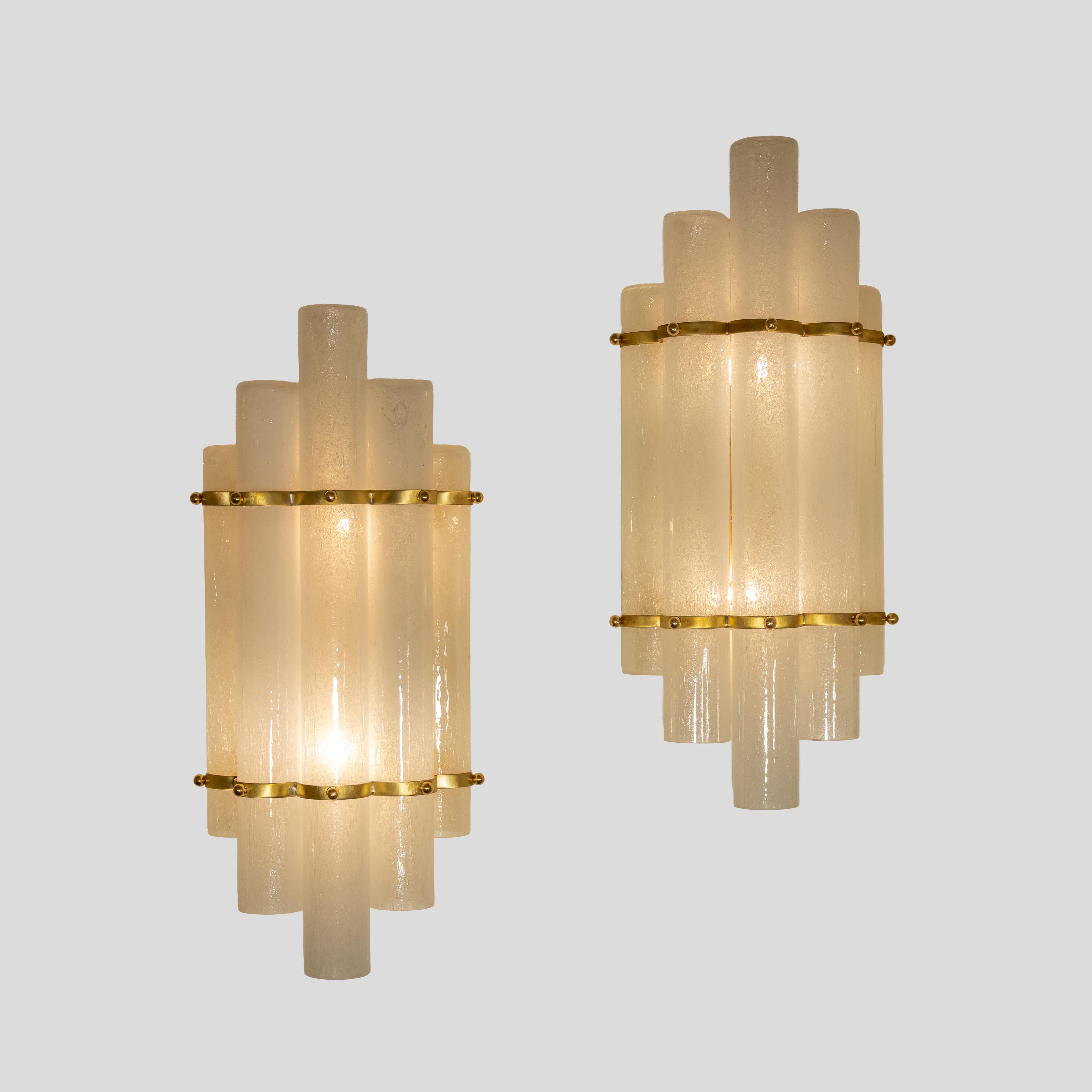 Coppia di applique Tubi. Componenti in vetro soffiato con tecnica Pulegoso su struttura metallica in ottone.

2 lampadine Max 40 Watt
Cablato per lavorare negli Stati Uniti e in Europa