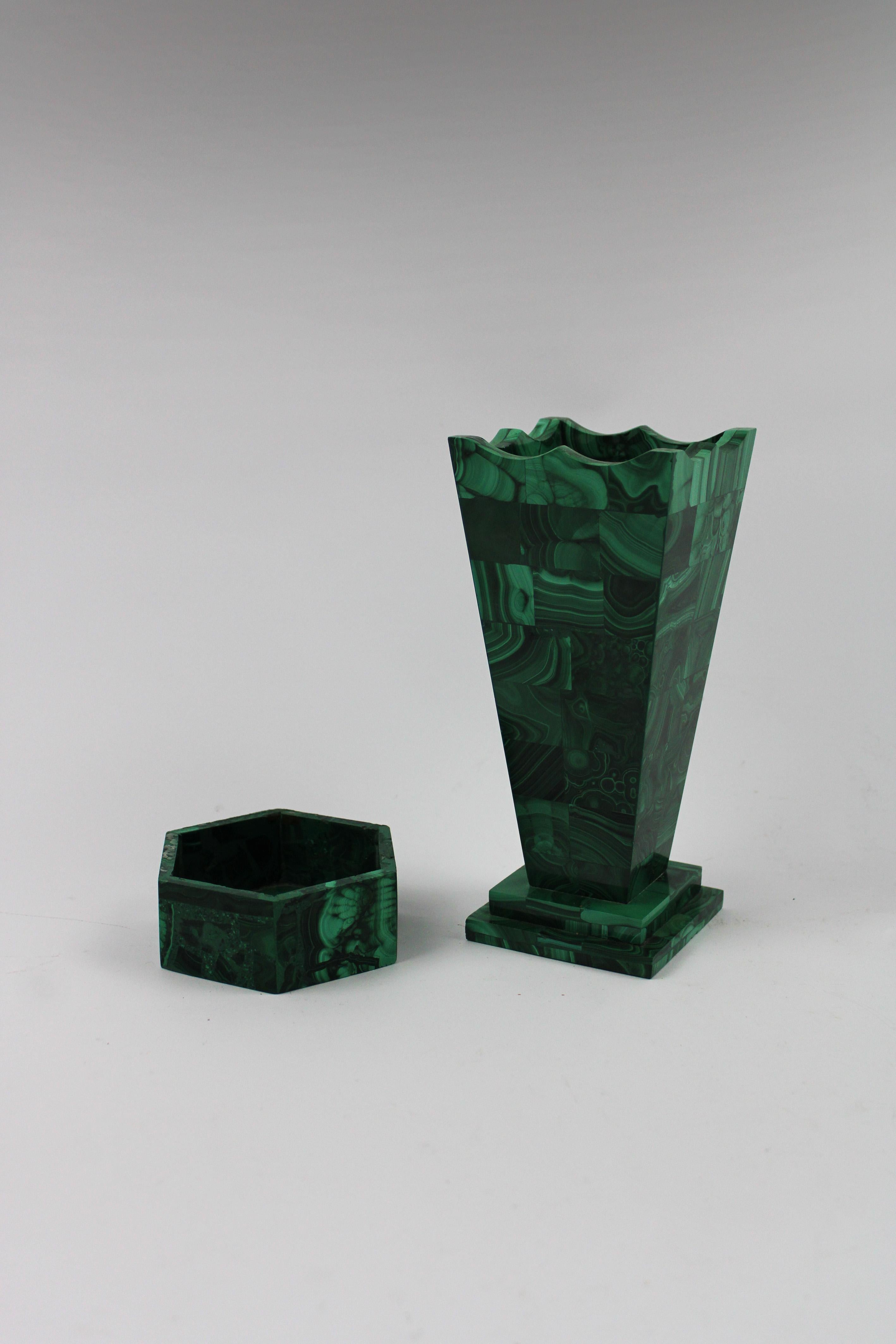 This exquisite set of two handmade malachite pieces, originating from the rich mineral deposits of the Congo, perfectly captures the style of the timeless elegance of Art Deco. The set includes a striking square vase and a unique hexagonal trinket