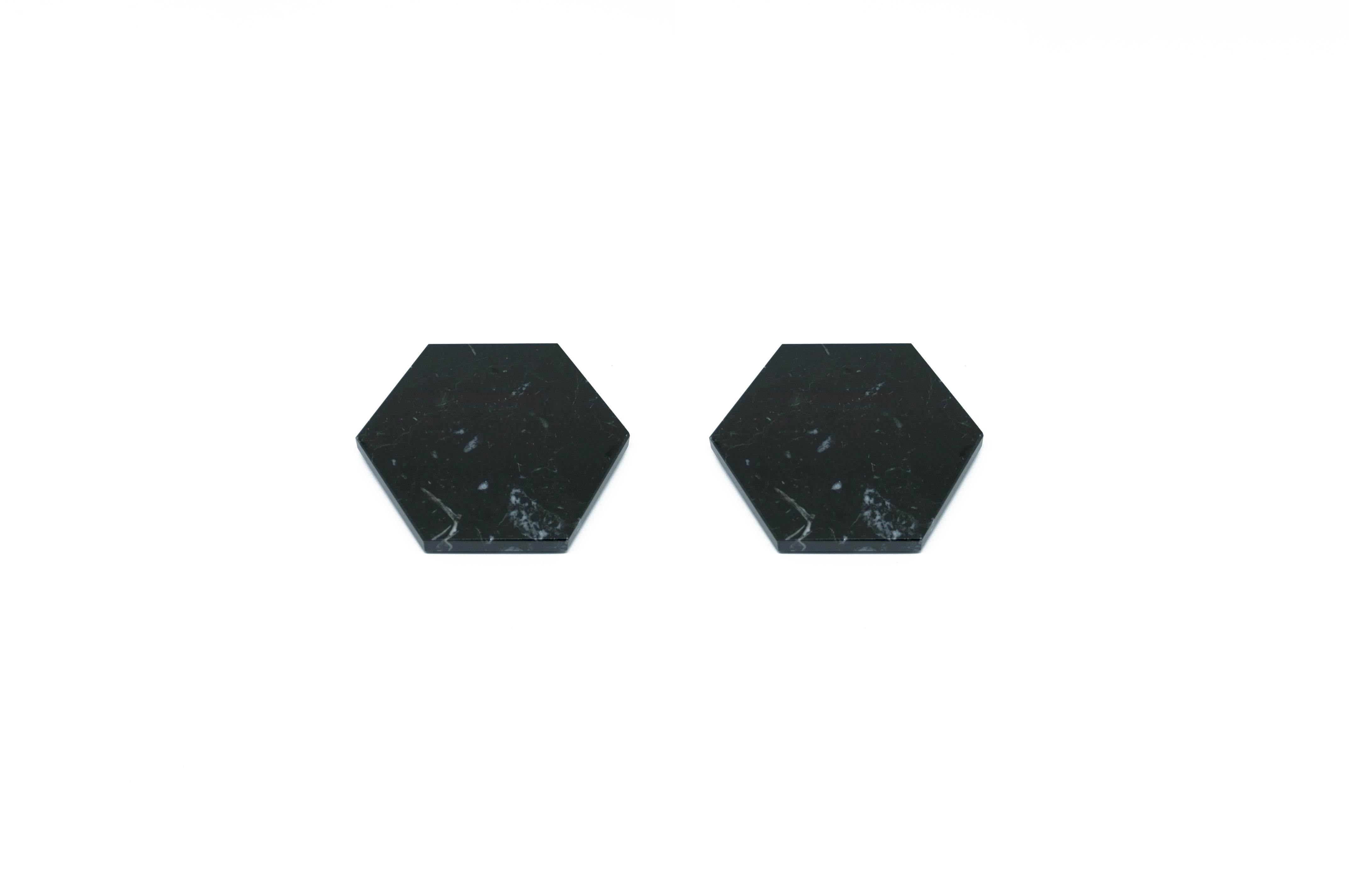 Set of 2 hexagonal shape black marble coasters with cork underneath. Each piece is in a way unique (every marble block is different in veins and shades) and handmade by Italian artisans specialized over generations in processing marble. Slight