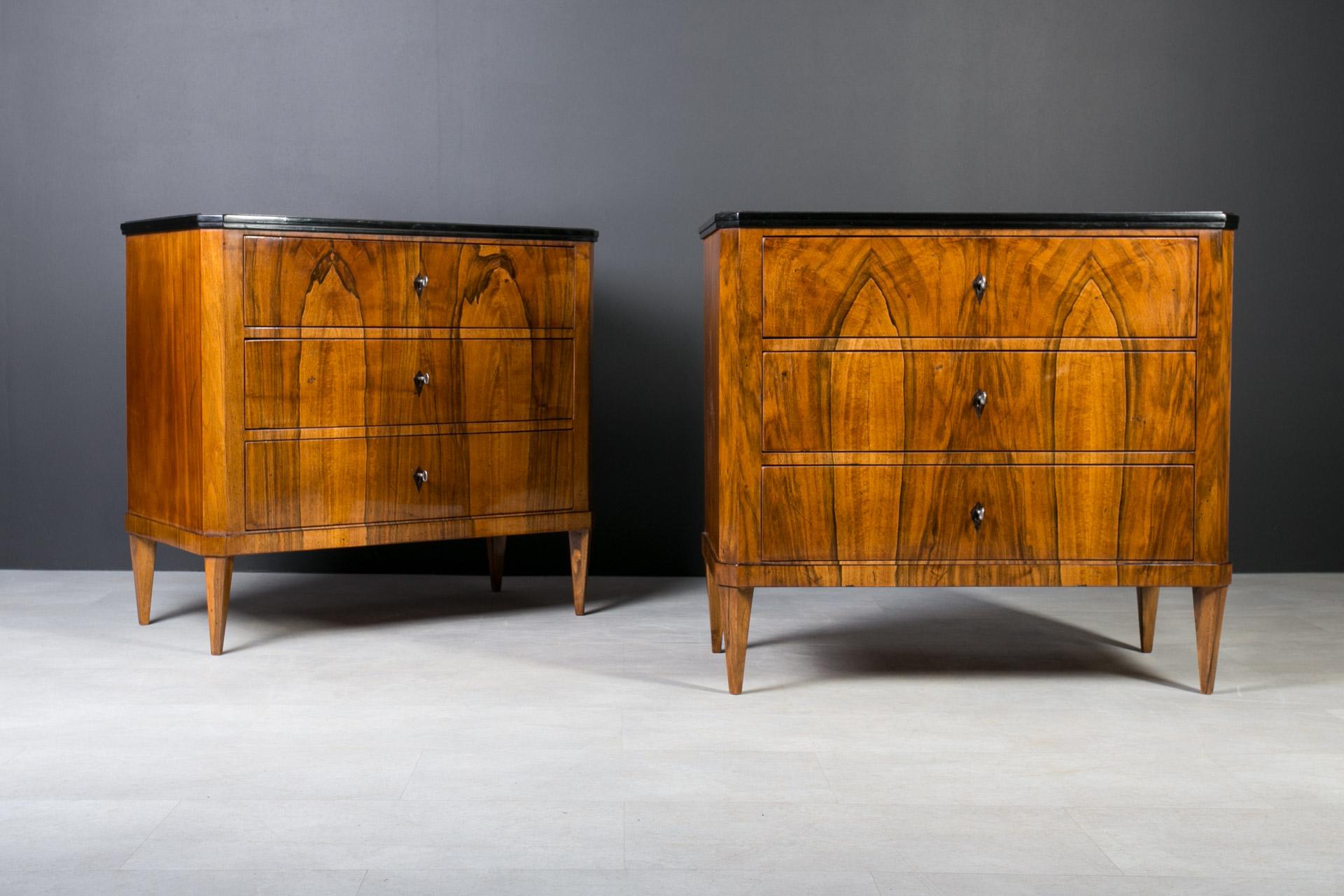 These 2 Biedermeier chests of drawers were made in 19th century. They come from Germany. Veneered with beautiful walnut veneer.  Each chest features three spacious drawers lockable with keys. Each one is set on four slender legs that add extra