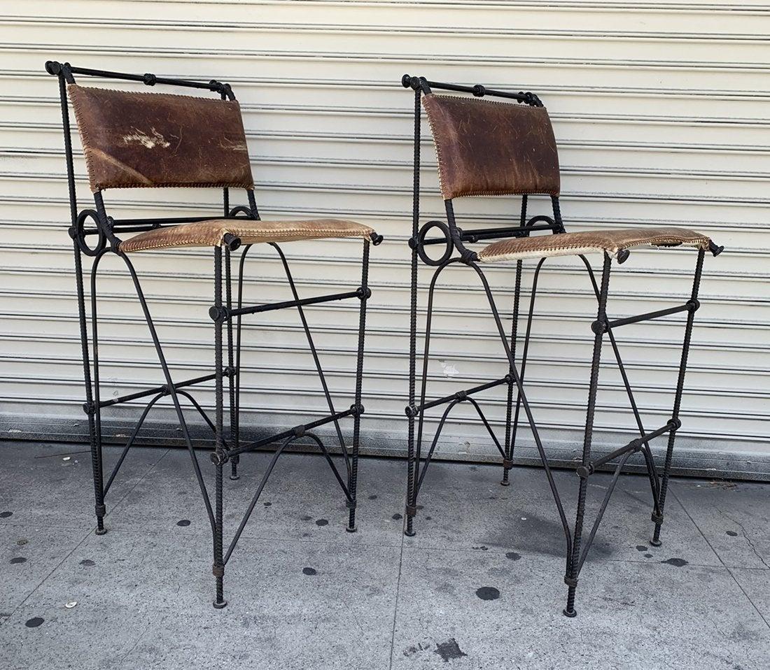 Artist, designer, and sculptor Ilana Goor's style is defined by modern forms made from unique and refined materials. 

Made/designed in the 1970s, these bar stools are made from burnt caramel leather with sewn edges set over a handmade Rebar iron