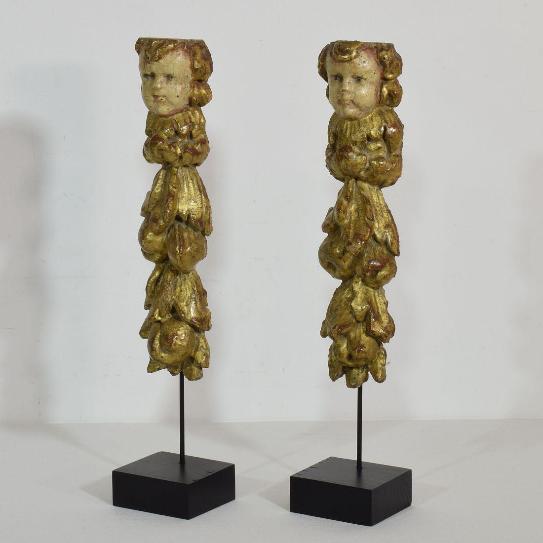 Unique carved wooden ornaments with angel heads, Italy, circa 1750. Weathered.
Measurement includes the wooden base.










  