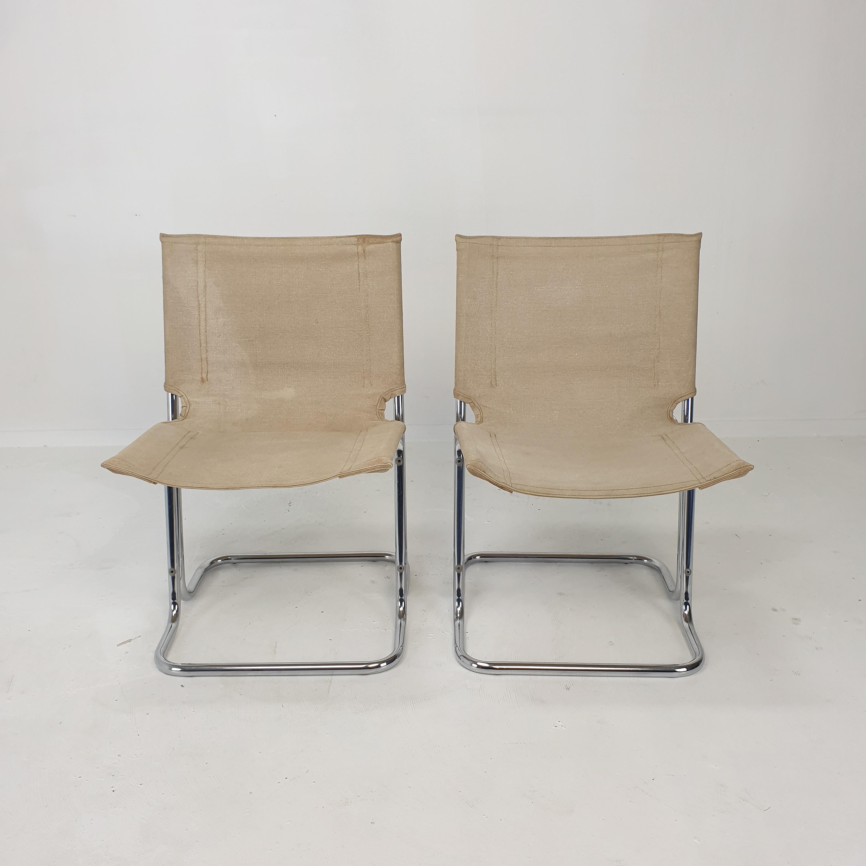 Very nice set of 2 Italian (dining) chairs, fabricated in the 70's. 

A striking design with interesting details resulting in an architectural appearance. 

Both seat- and backrest have their high quality original canvas covers, with traces of