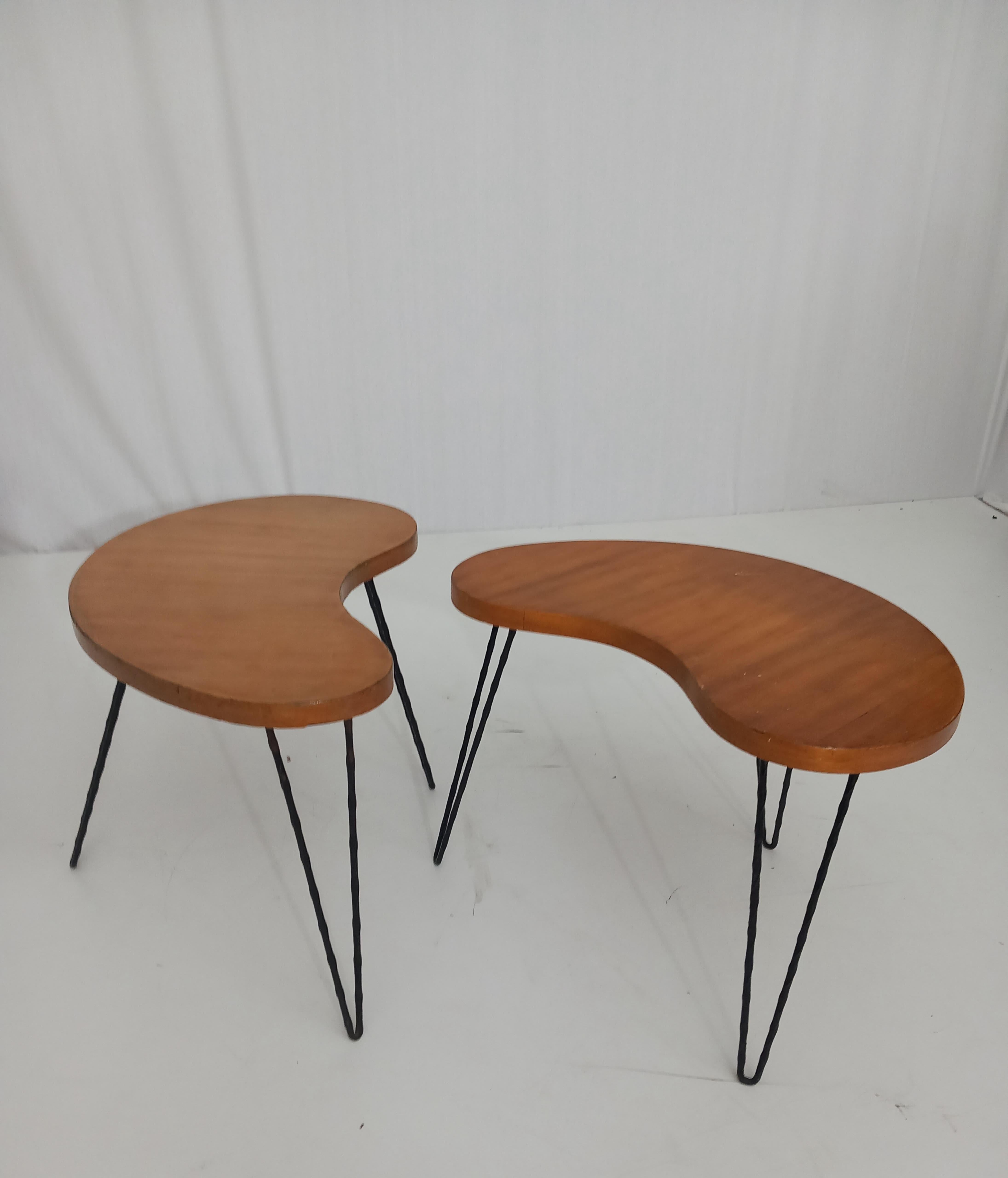 A beautifully crafted set of two small tables, designed and produced in Italy in the 1950s, showcasing the elegance and quality of mid-century Italian design. These tables feature a peculiar shape that sets them apart, combining walnut wood with