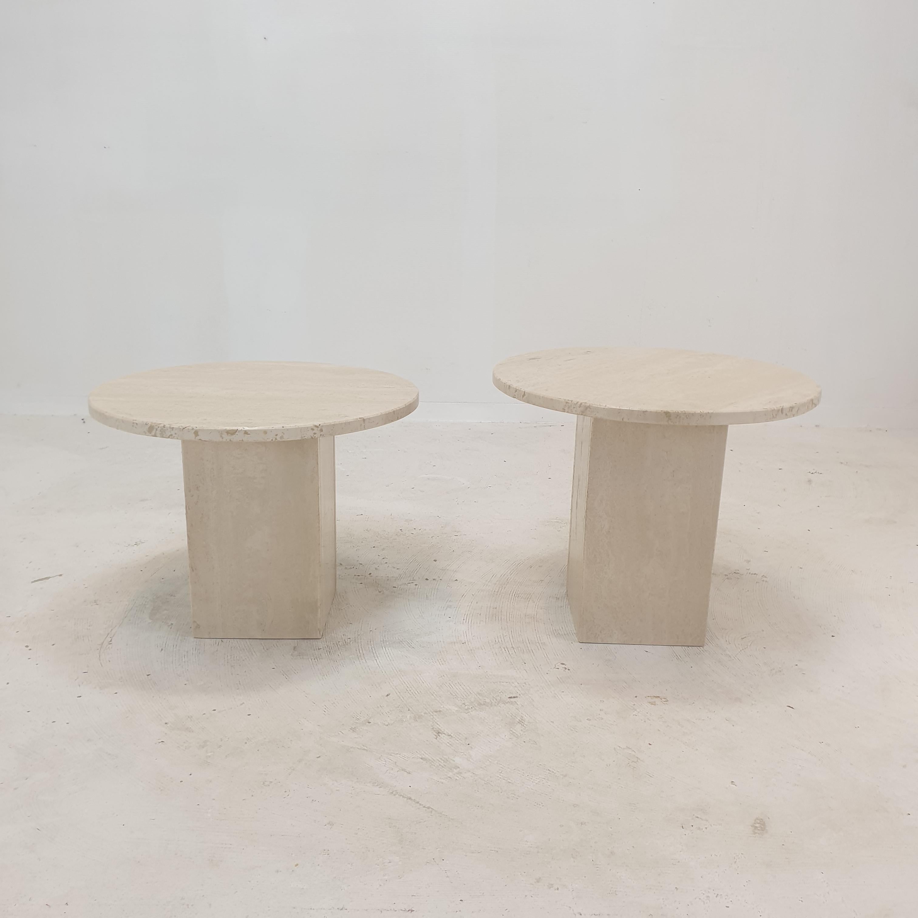 Stunning set of 2 Italian coffee or side tables, handcrafted out of travertine. 
They can be used inside or outside the house.

The tables have a different height so they fit under each other. 

The round plate and the square base are made of