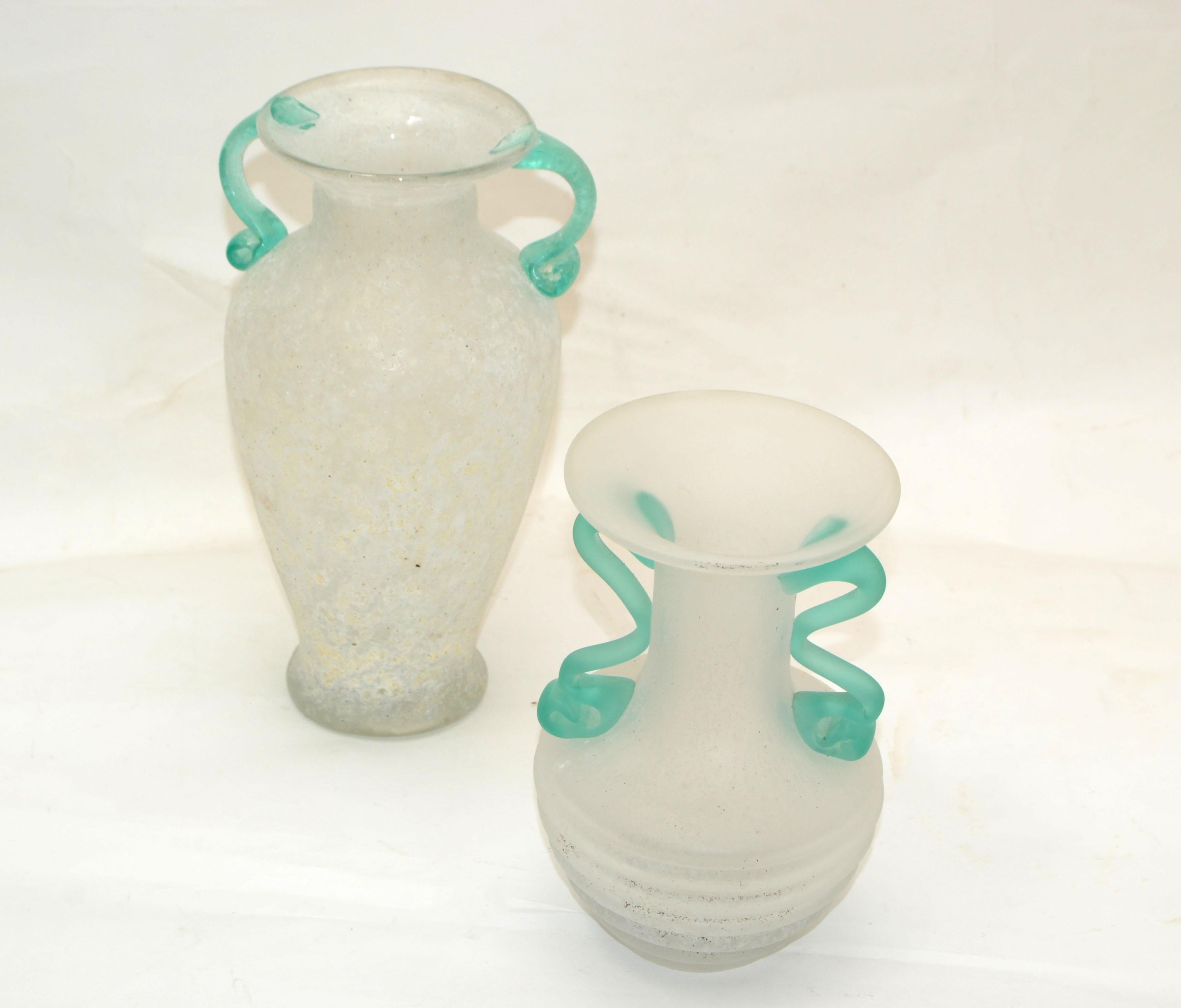 Ensemble de 2 vases, récipients et carafes en verre scavo blanc et vert menthe en verre d'art de Murano Mid-Century Modern fabriqué en Italie en 1980.
Le plus petit vase mesure : 6.5 pouces de hauteur.