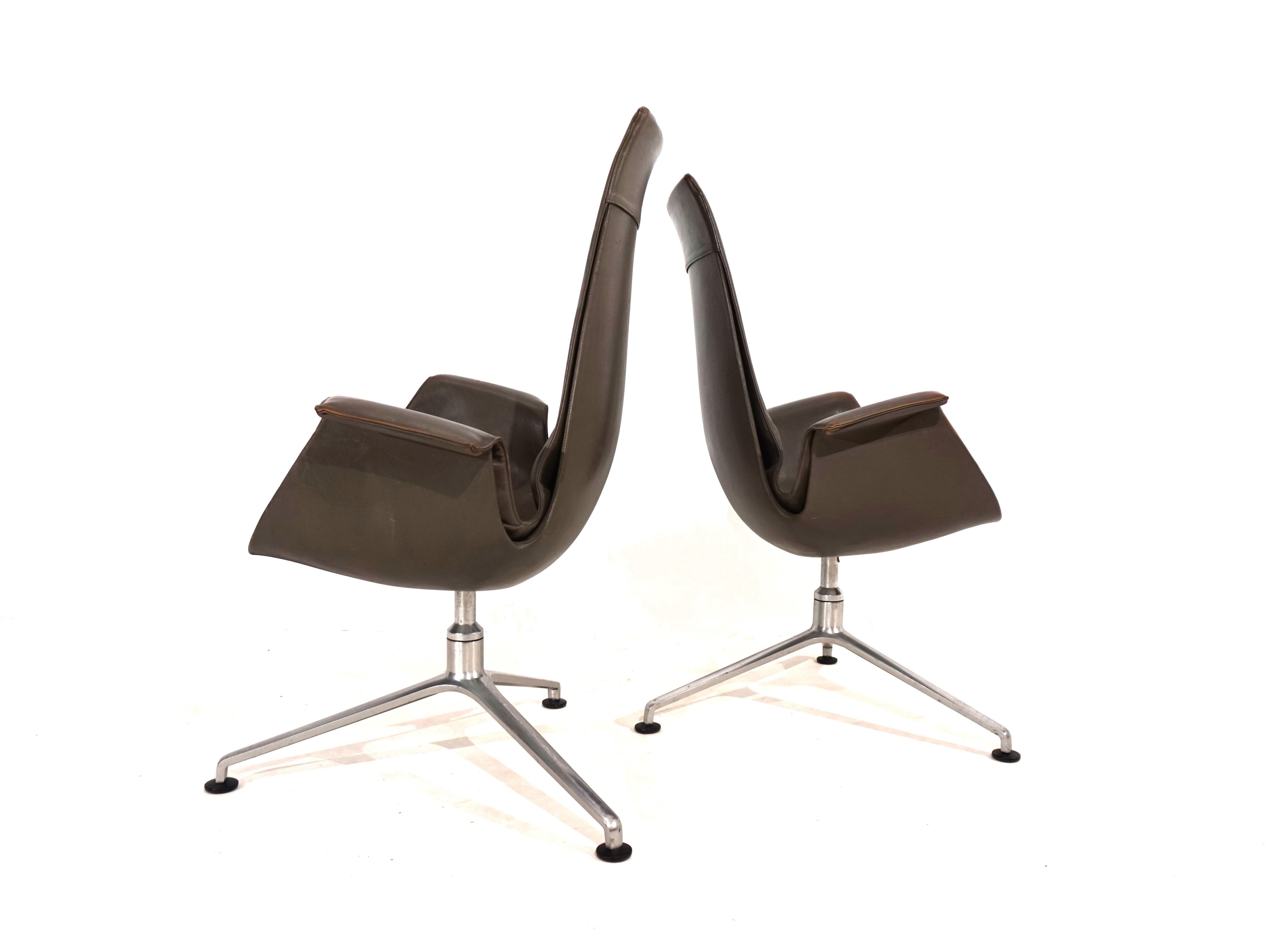 This pair of elegant FK 6725 Bird high back chairs comes in very good condition. The taupe-colored leather of the chairs shows hardly any signs of wear and has a charming patina on the armrests. The typical tripod frames show age-appropriate signs