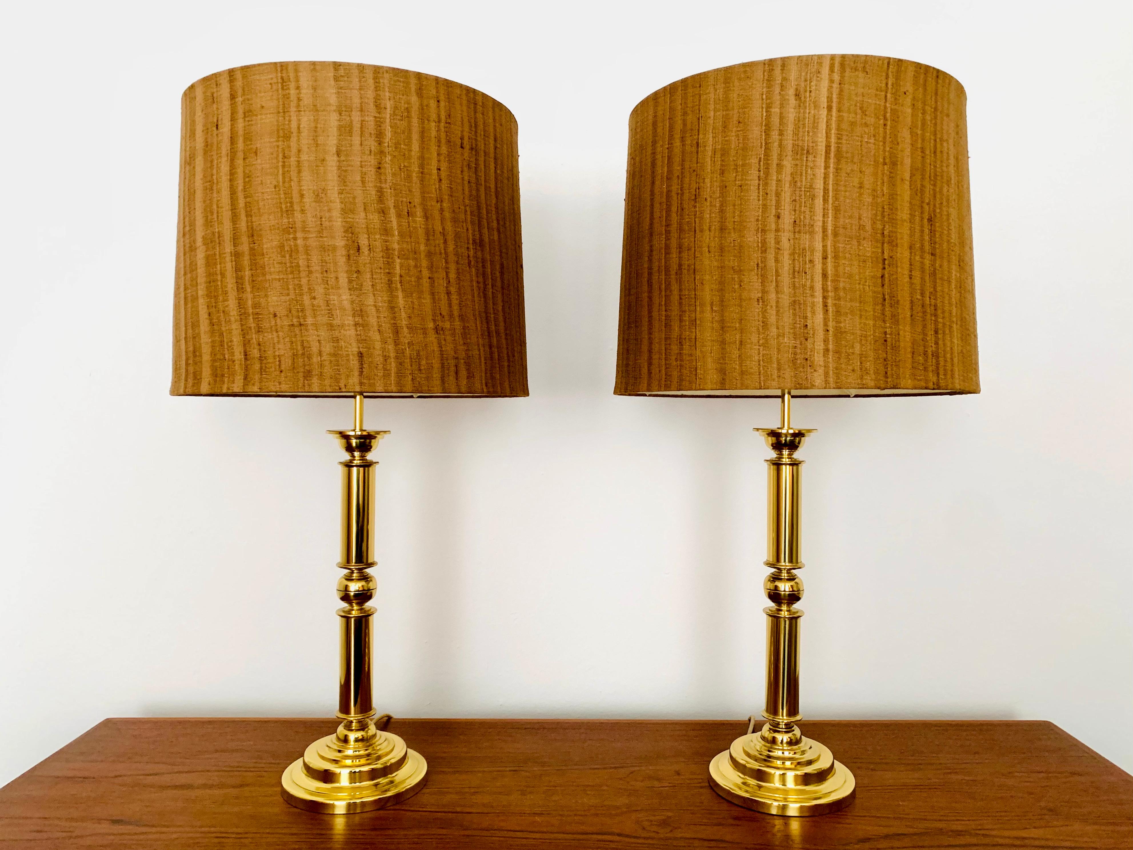 Impressionnante paire de lampes de table en laiton des années 1960.
Un design extraordinairement réussi et une fabrication allemande de très haute qualité.
La belle structure des abat-jour crée une atmosphère lumineuse agréable et
