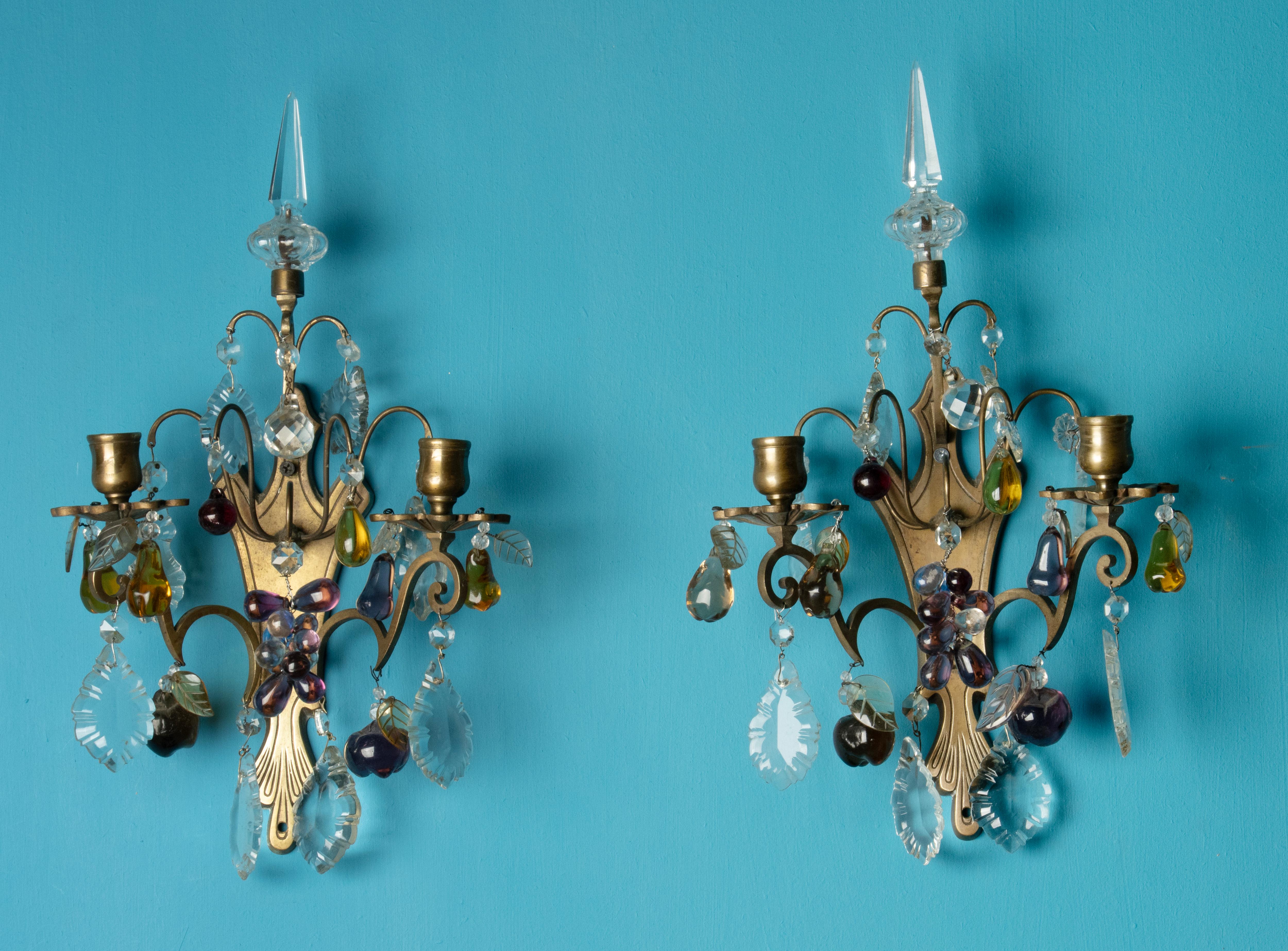 Precioso juego de dos candelabros de pared antiguos, de latón, decorados con carámbanos de cristal y formas frutales de cristal.
Estas lámparas no son eléctricas, son candelabros para velas.
Edad y origen estimados: Francia, hacia 1930.
El conjunto