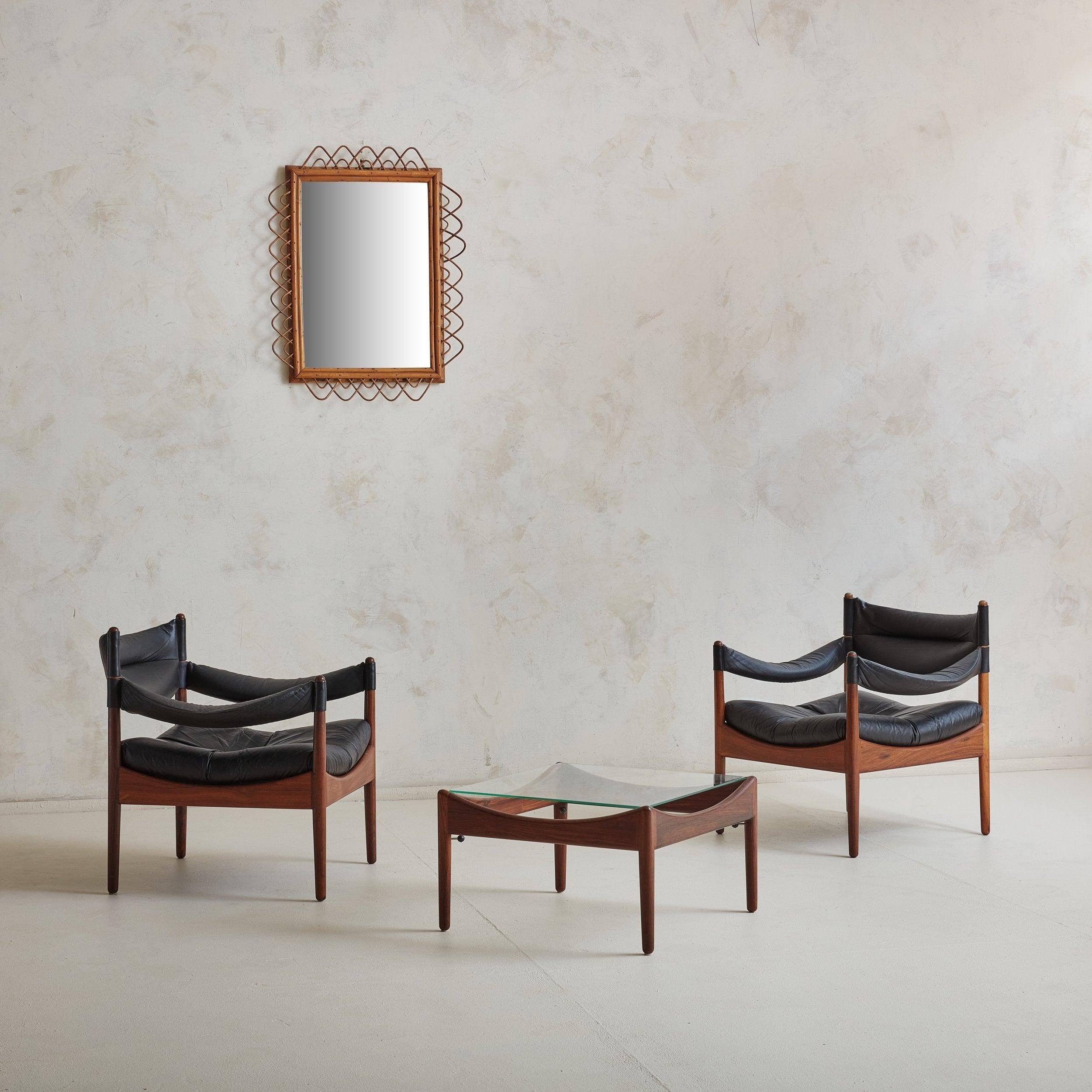 Set of 2 Danish Modern black leather armchairs and matching table from the Modus series, designed by Kristian Vedel for Willadsen Møbelfabrik. This 1960s Scandinavian Modern set features gorgeous rosewood frames with curved details and minimalistic