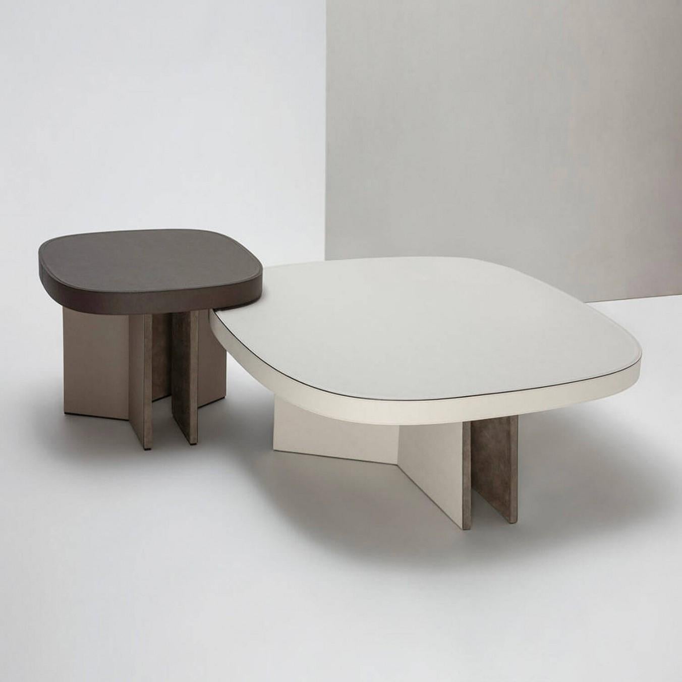 Set of 2 contemporary leather coffee tables - bivio by Stephane Parmentier for Giobagnara.

Bivio (meaning “junction” in Italian) collection is characterized by an architectural base made of three folded wooden slabs lined in suede and leather.