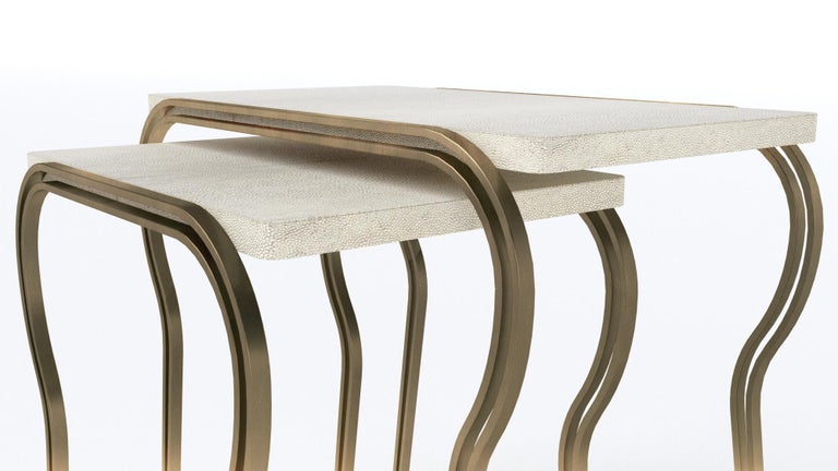 The set of 2 Lola Nesting side tables by R&Y Augousti, inlaid in cream shagreen, are an elegant design that is adaptable to many different spaces. The thin and sculptural bronze-patina brass legs make the tops appear as though they are floating,
