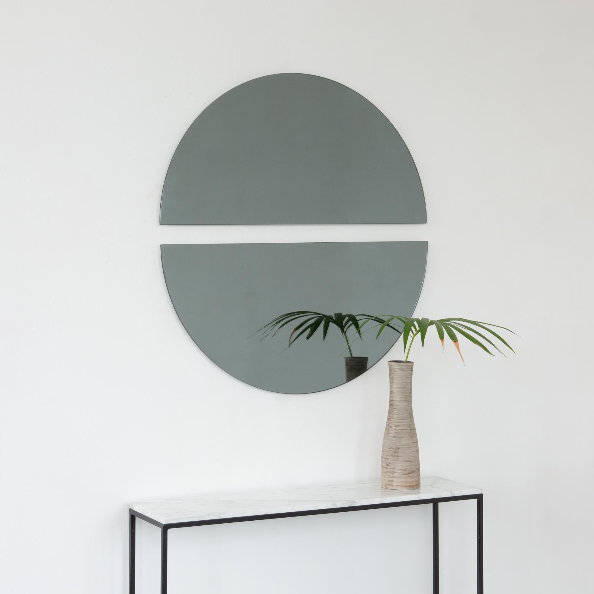 Set of two minimalist half-moon Luna™ black tinted frameless mirrors with a floating effect. Fitted with a quality and ingenious hanging system for a flexible installation in 4 different directions. Designed and made in London, UK. 

The backing has