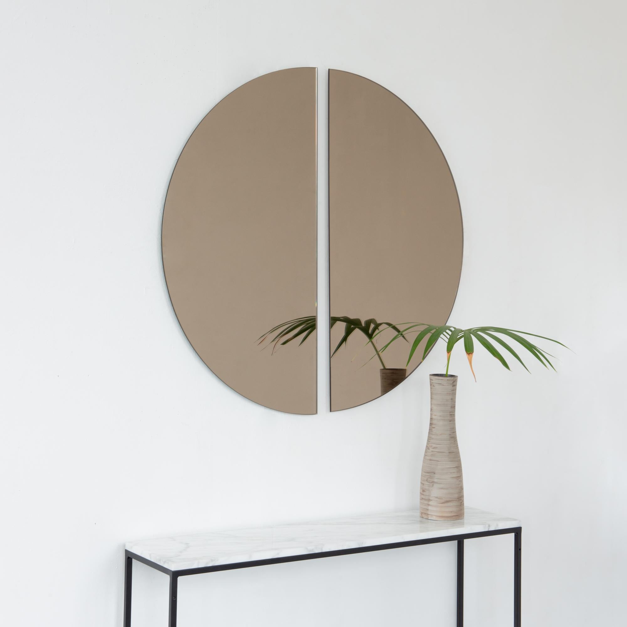NEW DESIGN

Set of two charming and minimalist half-moon bronze tinted frameless mirrors with a floating effect. Fitted with a quality and ingenious hanging system for a flexible installation in 4 different directions. Designed and made in London,