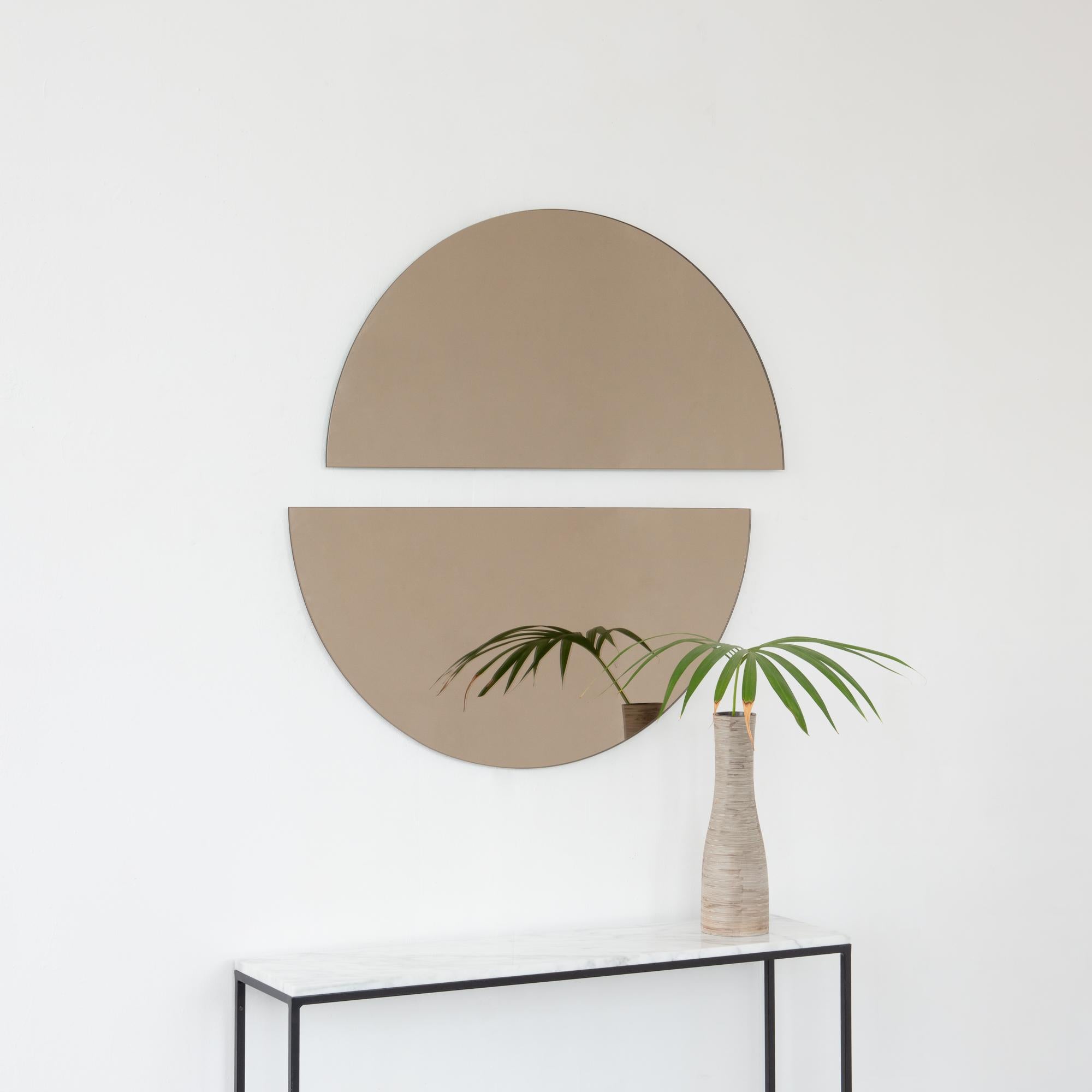 Set of two minimalist half-moon Luna™ bronze tinted frameless mirrors with a floating effect. Fitted with a quality hanging system for a flexible installation in 4 different directions. Designed and made in London, UK. 

Our mirrors