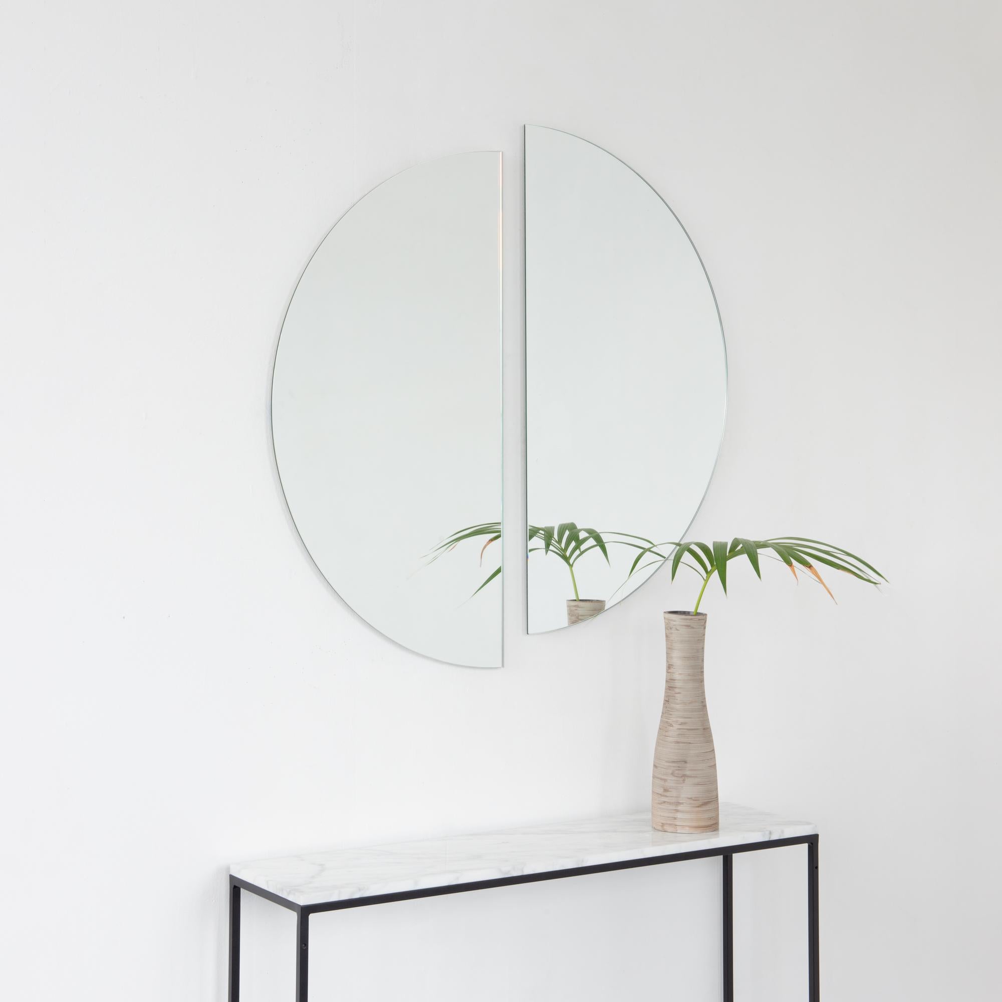 Lot de deux miroirs sans cadre Luna™ demi-lune charmants et minimalistes avec un effet flottant. Équipé d'un système d'accrochage ingénieux et de qualité pour une installation flexible dans 4 directions différentes. Conçu et fabriqué à Londres, au