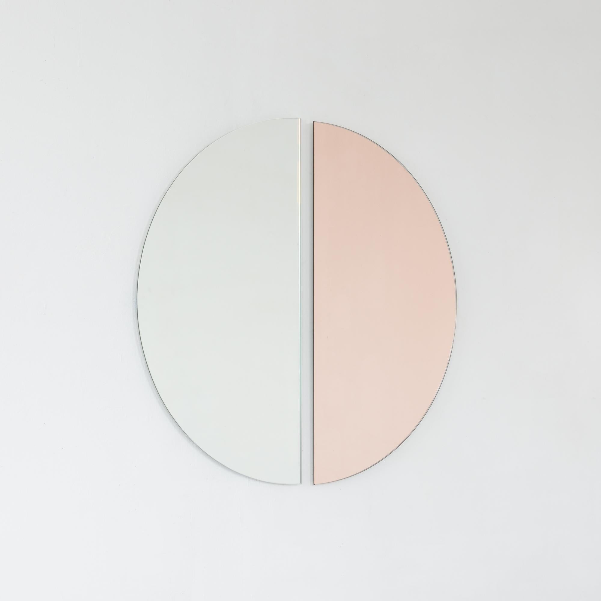 Set of two Luna™ minimalist rose gold (peach) and standard silver half-moon frameless mirrors with a floating effect. Fitted with a quality hanging system for a flexible installation in 4 different directions. Designed and made in London, UK. 

Our