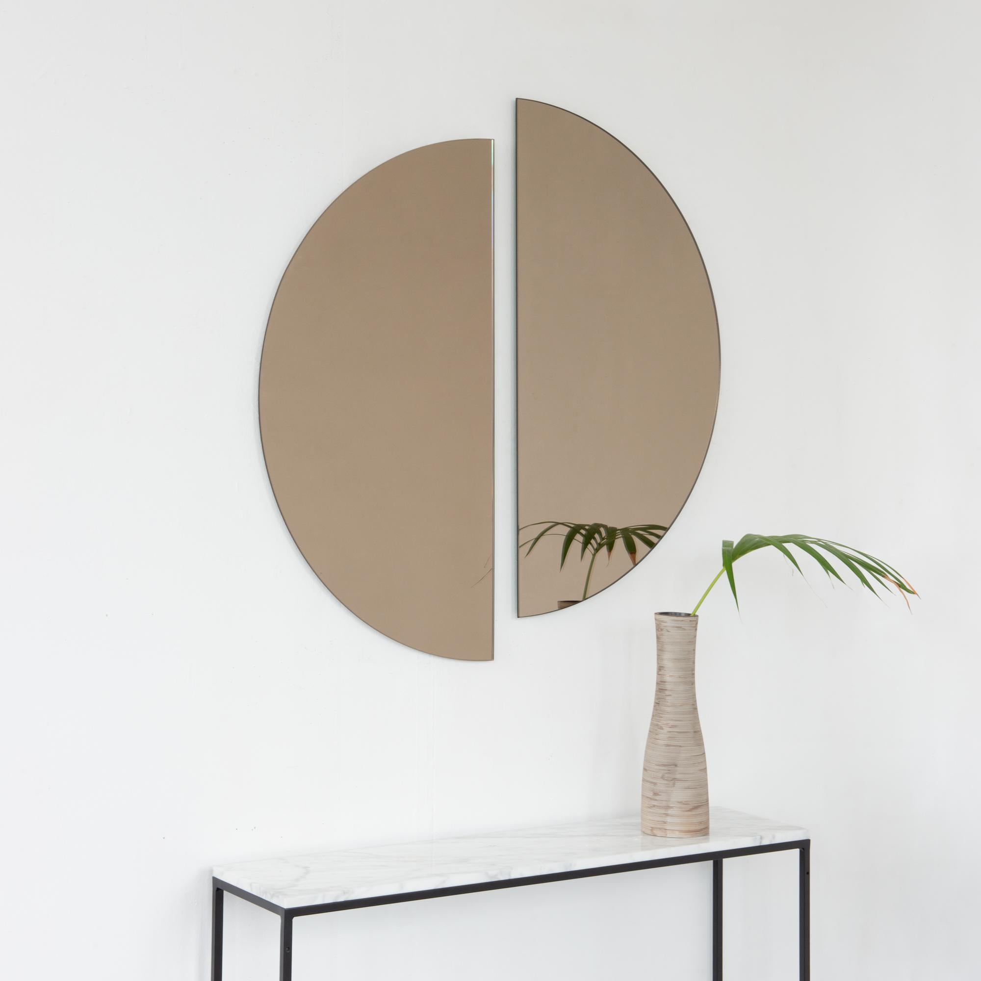 Set of two minimalist half-moon Luna™ bronze tinted frameless mirrors with a floating effect. Fitted with a quality and ingenious hanging system for a flexible installation in 4 different directions. Designed and made in London, UK. 

The backing