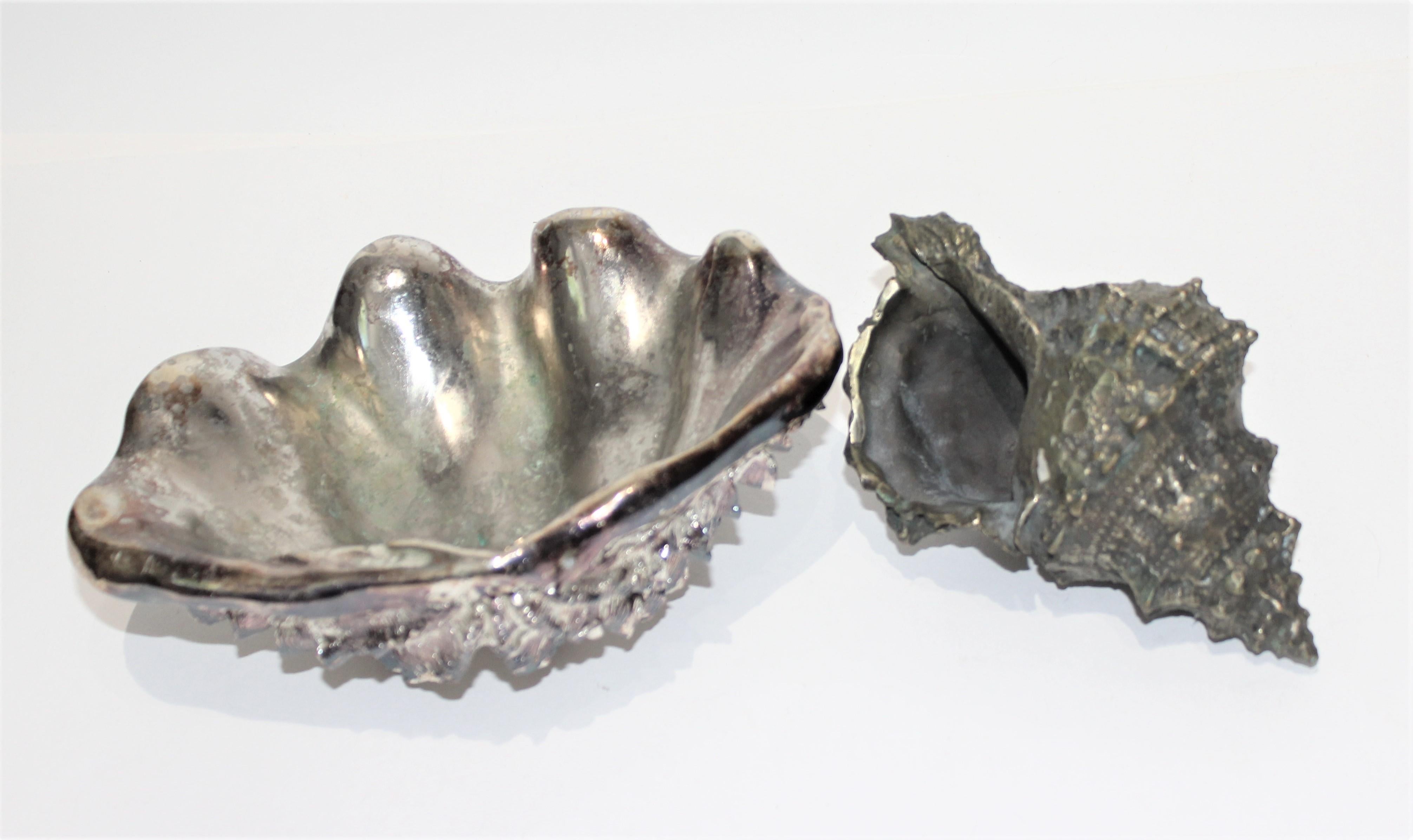 Shell Sculptures Ribbed Clam and Conch - set of 2 from a Palm Beach estate

The ribbed clam is made from heavy resin material and appears to have been used as a luxe soap dish.
The snail conch is made of metai.

Clam 8