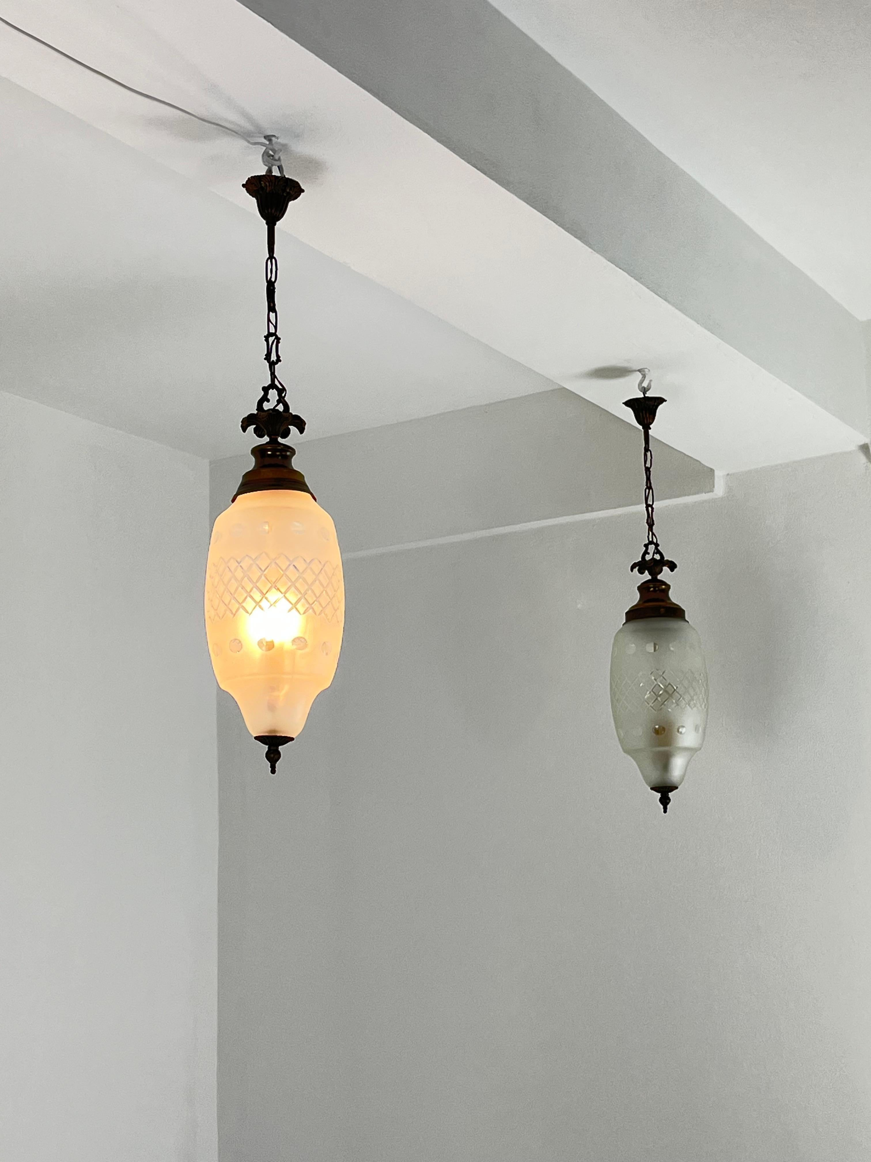 Set di 2 lampade a sospensione a 2 luci del Mid-Century attribuite a Luigi Caccia Dominioni, anni '60
Struttura in metallo e coppe in vetro di Murano lavorate a mano (si possono notare piccole bolle d'aria, tipiche della lavorazione manuale dei