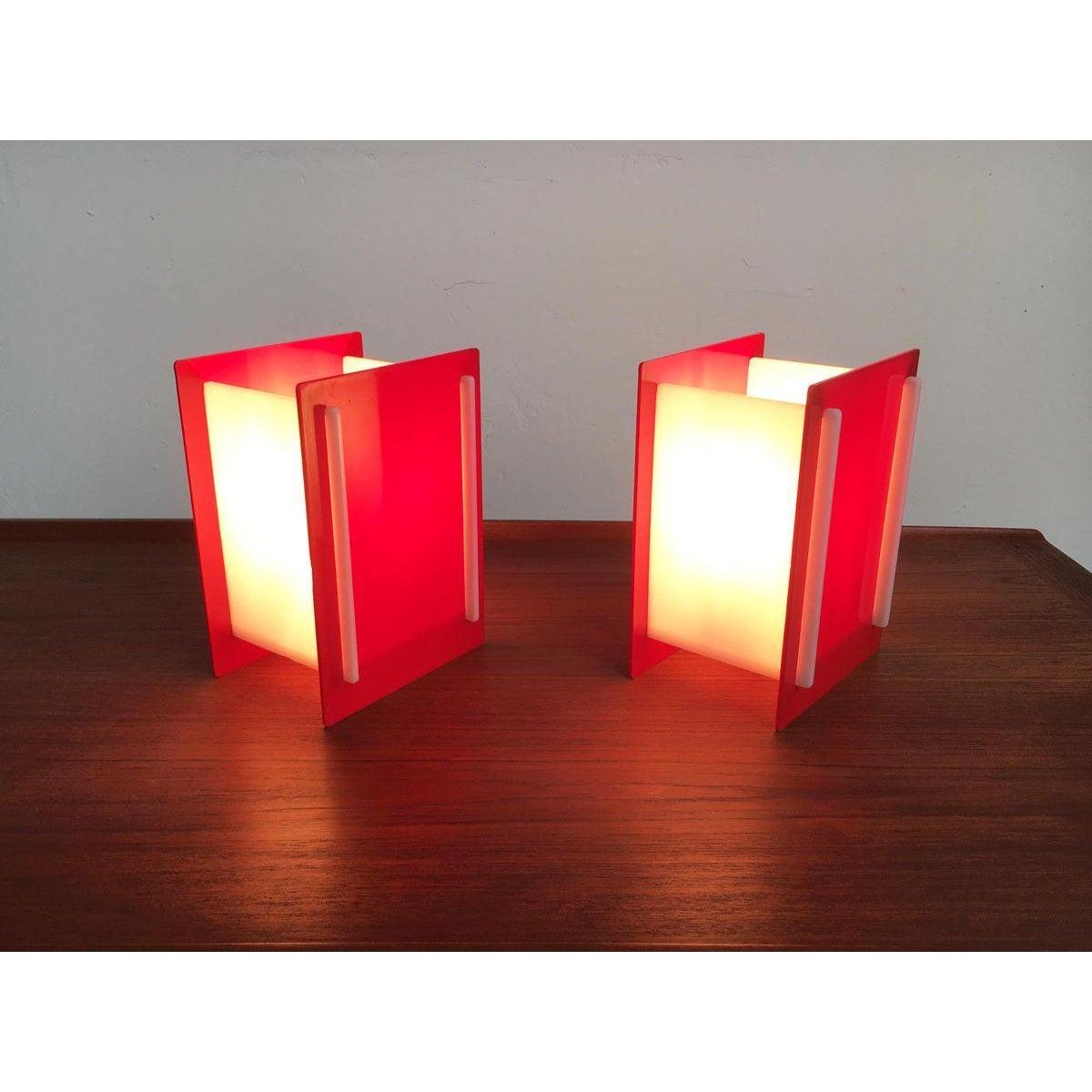 2 lampes de table en acrylique translucide en blanc et rouge.

Le langage de conception est très simple et d'une simplicité intemporelle. Les lampes sont constituées de disques qui sont insérés les uns dans les autres avec des protubérances