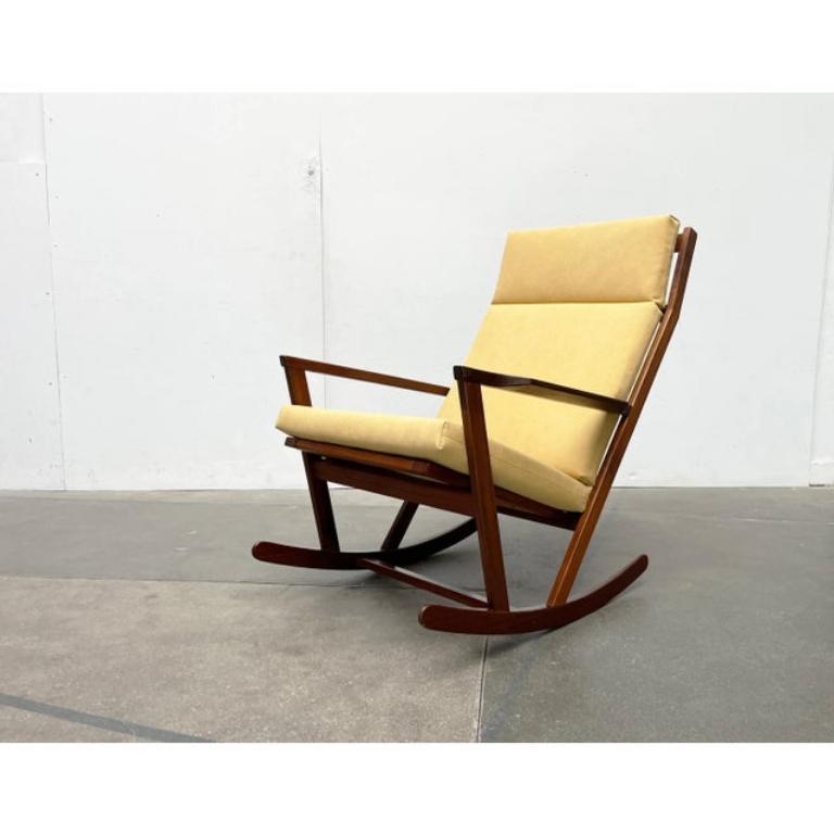Fauteuil à bascule simple du fabricant danois frem røjle d'après un design de poul volther datant des années 1960. Ici en combinaison avec le très rare ottoman.

Un design très objectif avec des lignes claires. Les différents éléments en bois massif