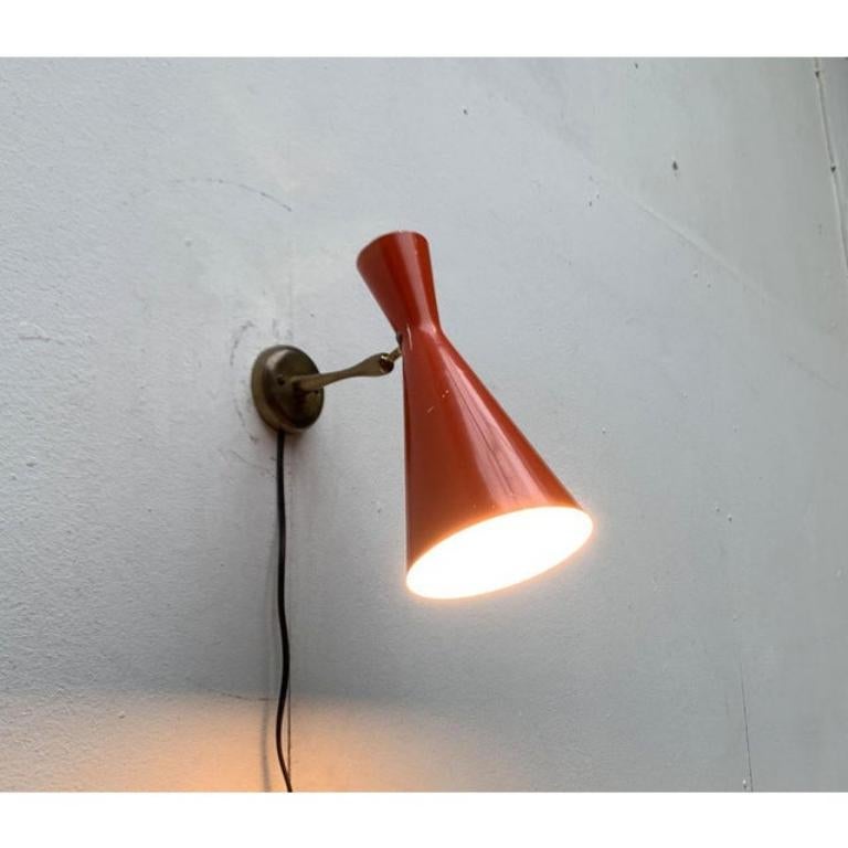Dos apliques de pared de mediados de siglo con paraguas Diábolo.

Un diseño factual con formas elegantes. El elemento más llamativo de esta lámpara es el gran paraguas de diábolo rojo. Se conecta a la base de la pared mediante una articulación y un