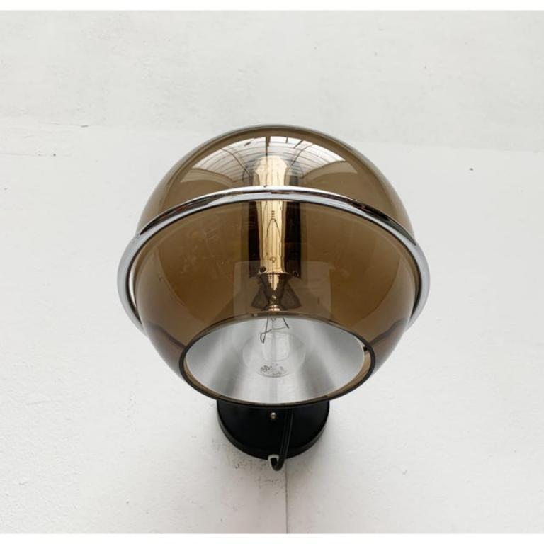Rare Space Age Globe wall lights from Dutch manufacturer raak based on a design by Frank Ligtelijn from the late 50s.

The most distinctive feature of this lamp is the reflector globe made of tinted glass. The glass luminaire body reveals the inner