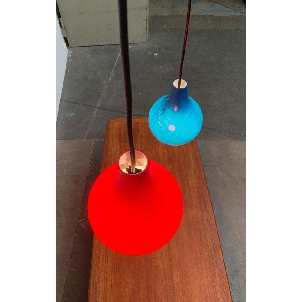 Péndulo de cristal de mediados de siglo del renombrado fabricante Putzler en colores muy especiales.

El cuerpo de la luminaria, de vidrio rojo o azul sobreacabado, presenta una elegante forma de gota. Abajo estás abierto y das luz directa. Al mismo