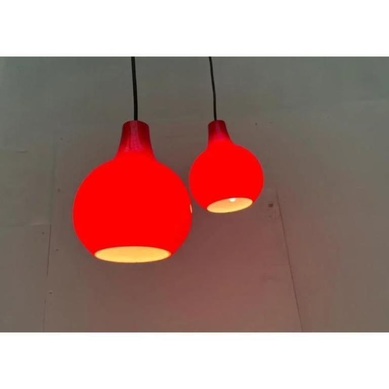 Pendolo in vetro di metà secolo del rinomato produttore Cleaner in colori molto particolari.

I corpi delle Luminaire in vetro rosso a vista mostrano un'elegante goccia di gocce. Sono aperti sotto e rilasciano luce diretta. Allo stesso tempo, i