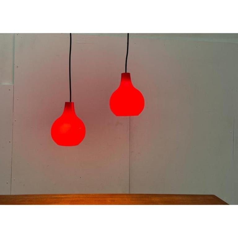 Mid-Century moderno Set di 2 lampade a sospensione in vetro rosso tedesco di metà secolo di Peill & Putzler, anni '60 in vendita