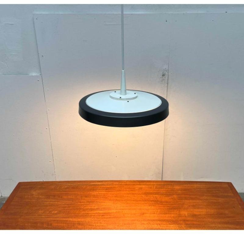 Pendolo ad asta minimalista di Staff.

Un design semplice ma di dimensioni impressionanti. Il corpo della lampada a forma di disco ha un diametro di ben 50 cm e pende da un'asta molto lunga. Le luci sono particolarmente adatte alle stanze con