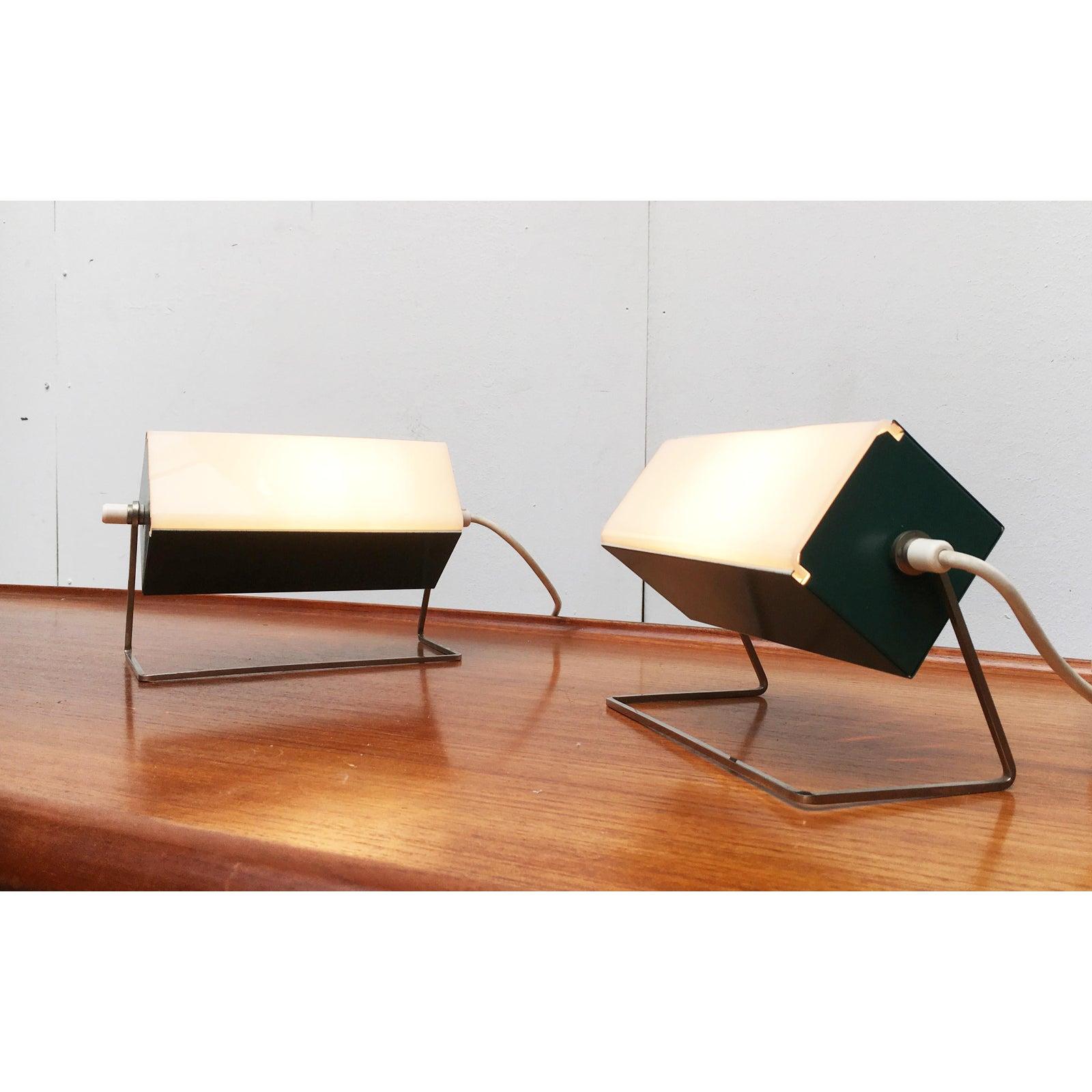 Minimalist Space Age desk lamps from Leclaire & Schäfer.

A very linear and delicate design. The cuboid body is made of green painted metal sheet. At the front, a translucent acrylic disc is fully inserted as a diffuser. On the back there is a