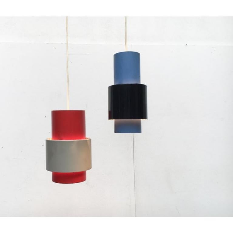 Due pesanti lampade a sospensione degli anni '60 in colori speciali.

un design semplice che colpisce per i suoi materiali e colori. Le lampade sono costituite da semplici cilindri con anelli di apertura collegati. Gli anelli sono contrassegnati da