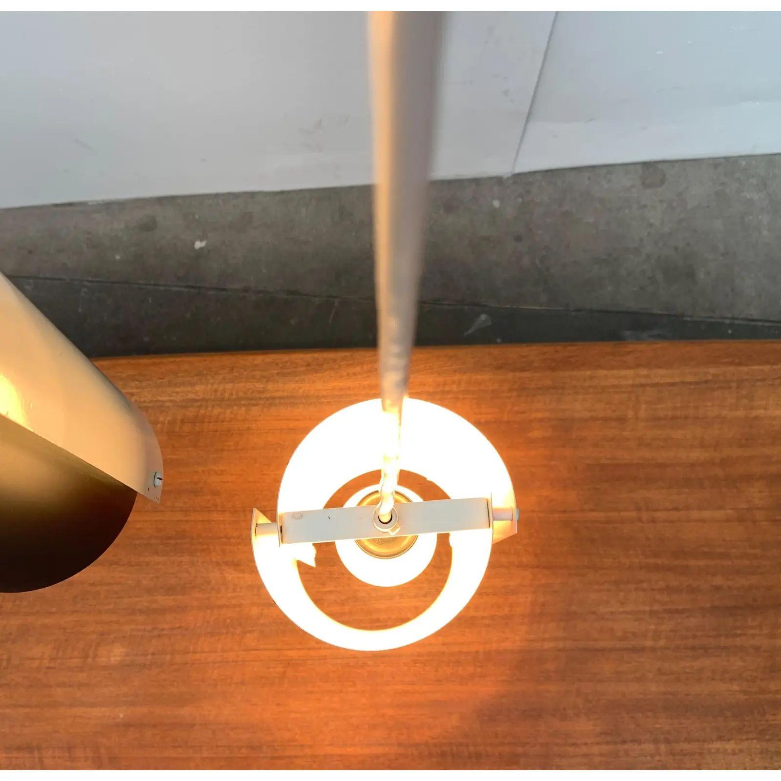 Semplici lampade a sospensione della metà del secolo scorso.

Un design minimalista. Due ciotole a forma di barile sono assemblate a distanza per formare un paralume cilindrico. Una ciotola è rifinita in bianco, l'altra in rosso o nero. La luce