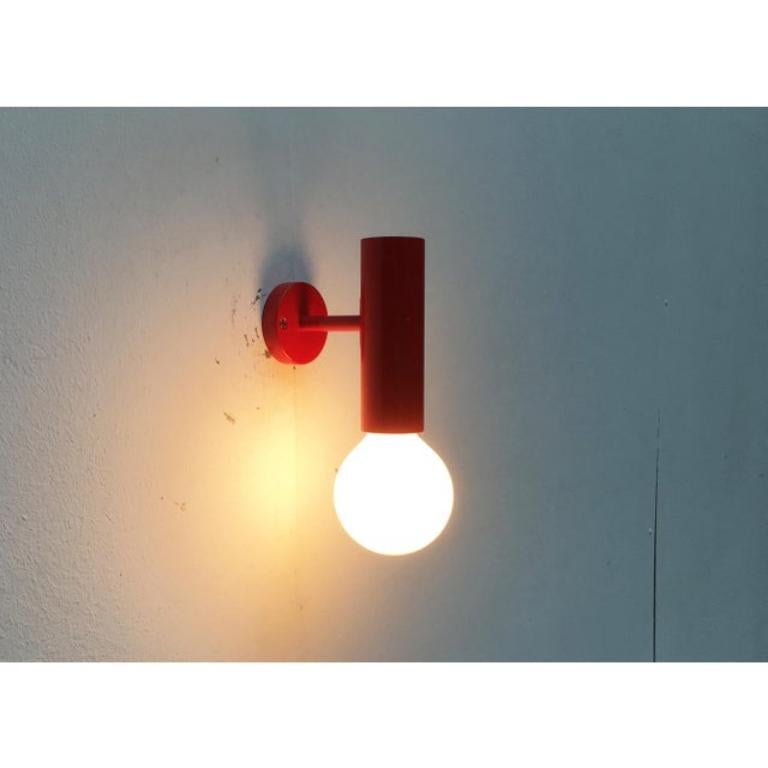 2 apliques de pared lisos Mid Century con un lenguaje de diseño muy sencillo.

Un cilindro rojo, en cuyo extremo se encuentra el casquillo para la bombilla. Se conecta a la placa de montaje mural mediante una barra estrecha. Una característica