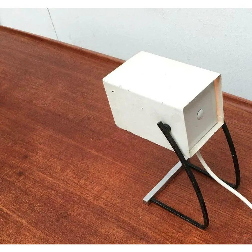 Due rare luci da tavolo della metà del secolo. Probabilmente da Kaiser.

Un design minimalista con una forma cubica di base. La testa del Luminaire è aperta e mobile su un lato. Questo può essere inclinato verso l'alto e verso il basso. Il piede si