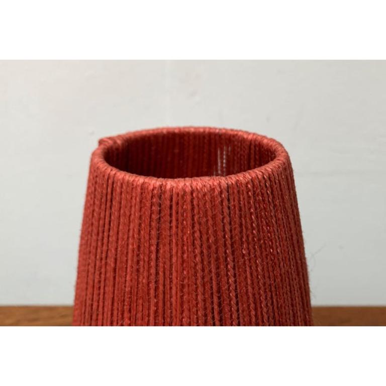 Two Mid-Century Tripod table lights.

A minimalist design with a special peaked material. The umbrellas are conical and open at the top. They are all around with a red cord. This special diffuser material ensures a particularly atmospheric lighting