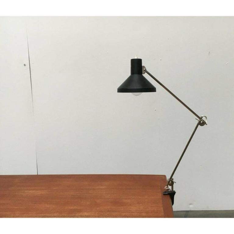 Rare desk lamps from Elux.

A design whose elegance is based on pure functionality. The two arms of these lights are simple rods that are fixed in disc joints. The joints can be locked using levers. The simple lampshade is black. The lights are
