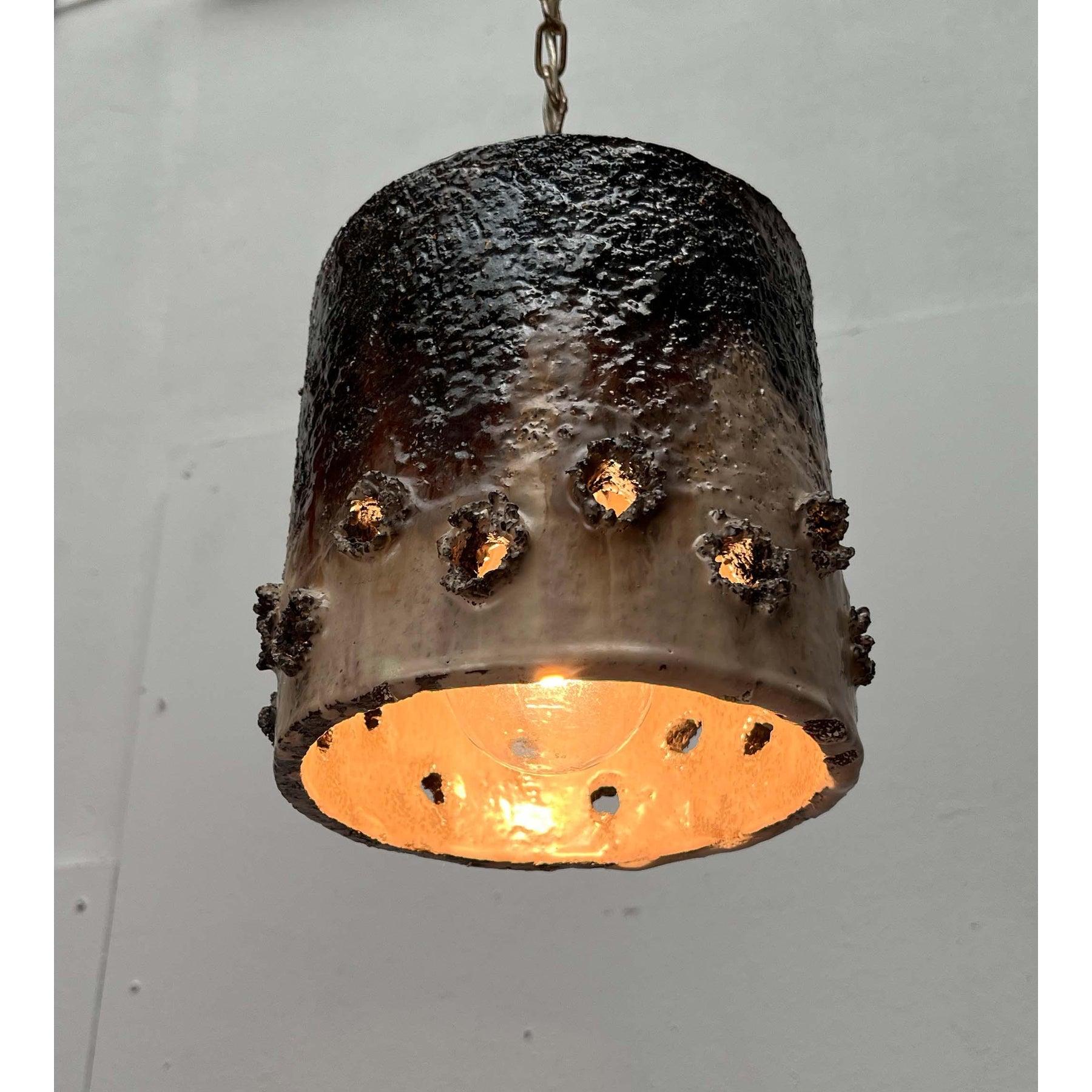 Brutalist studio ceramic pendant lights from Denmark with a striking lighting effect.

Simple ceramic lights that primarily attract attention with their atmospheric light. The lamp body has a simple cylindrical shape and is open at the bottom. The