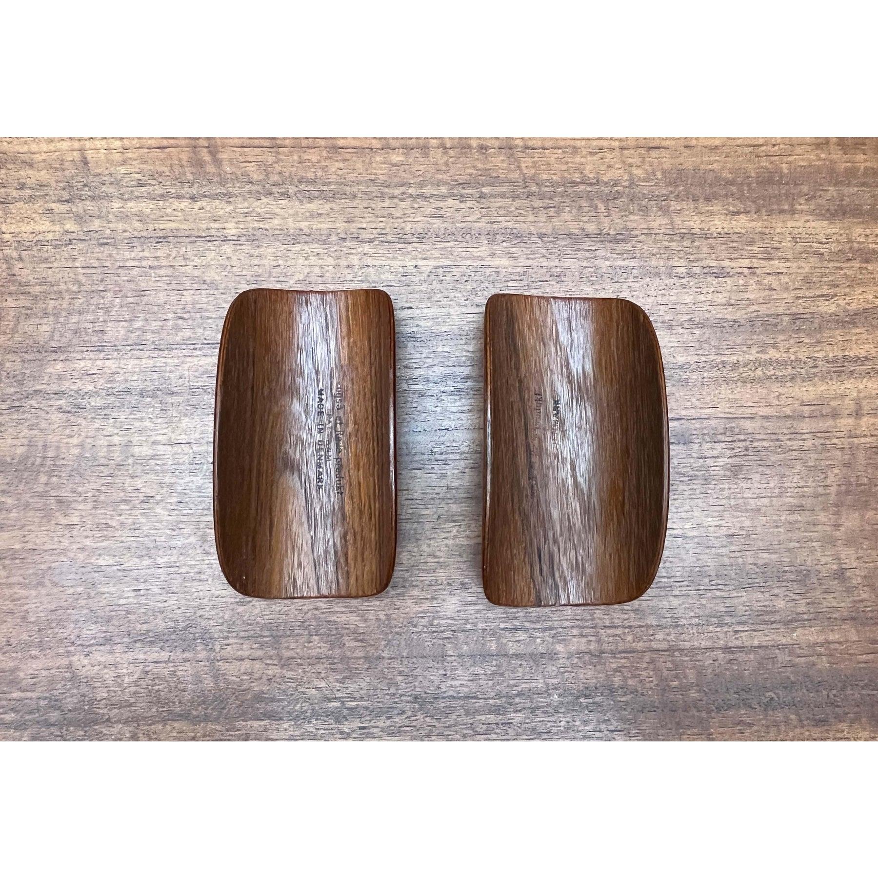 A very rare detail for the 150 armchair by Frem Røjle.

Two armrest pads made of molded plywood with teak veneer. These pads are usually missing or broken. They are simply clamped onto the armrests of the armchair. They are marked on the inside.
The