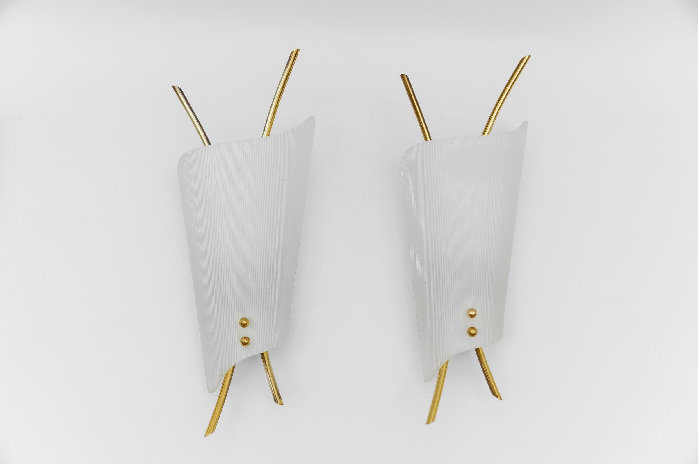 Set di due rare e bellissime lampade da parete Mid-Century Modern in acrilico e ottone. 

Ogni lampada necessita di 1 lampadina a vite E14 Edison. Sono cablati, funzionanti e funzionano sia a 110 che a 230 volt.

Ottime condizioni originali d'epoca.