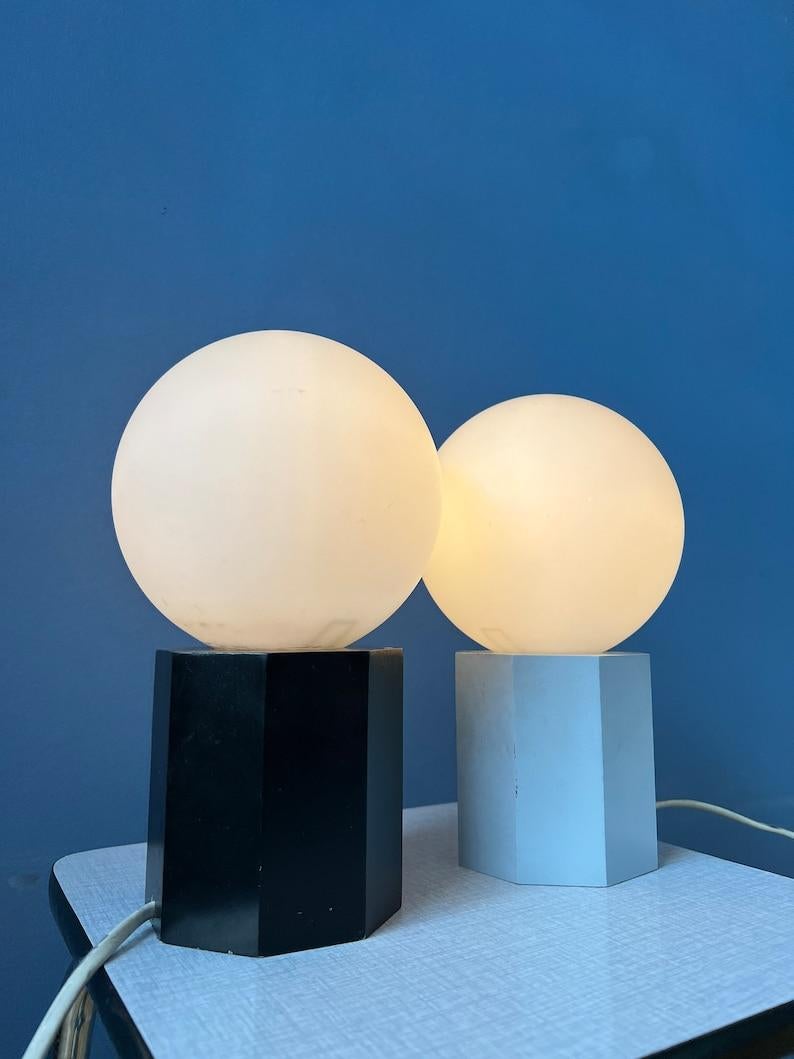 Ensemble de 2 lampes de table ou de chevet du milieu du siècle avec des abat-jours en verre opalin. Les bases sont en bois et ont une laque noire et grise. Les lampes nécessitent des ampoules E14 et sont actuellement dotées de fiches