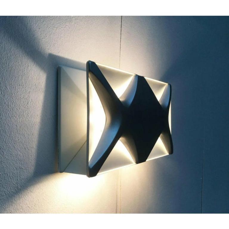 Rare wall lamp from Heinz Neuhaus Leuchten based on a design by Klaus Link from the 1960s. Due to the formal similarity to the Cross-Oyster, this design is often attributed to Rolf Krüger and Staff.

The lamp consists of three parts. The wall